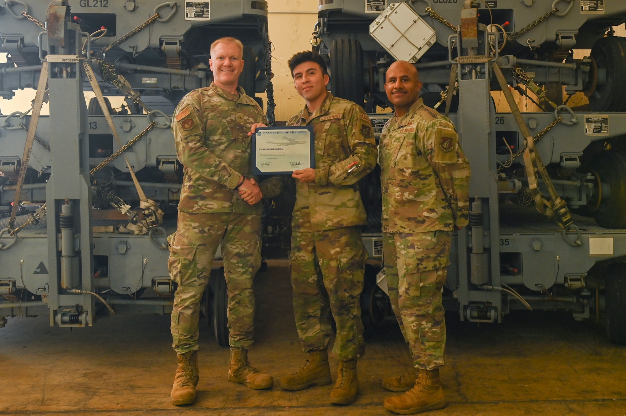 Three people pose with a certificate