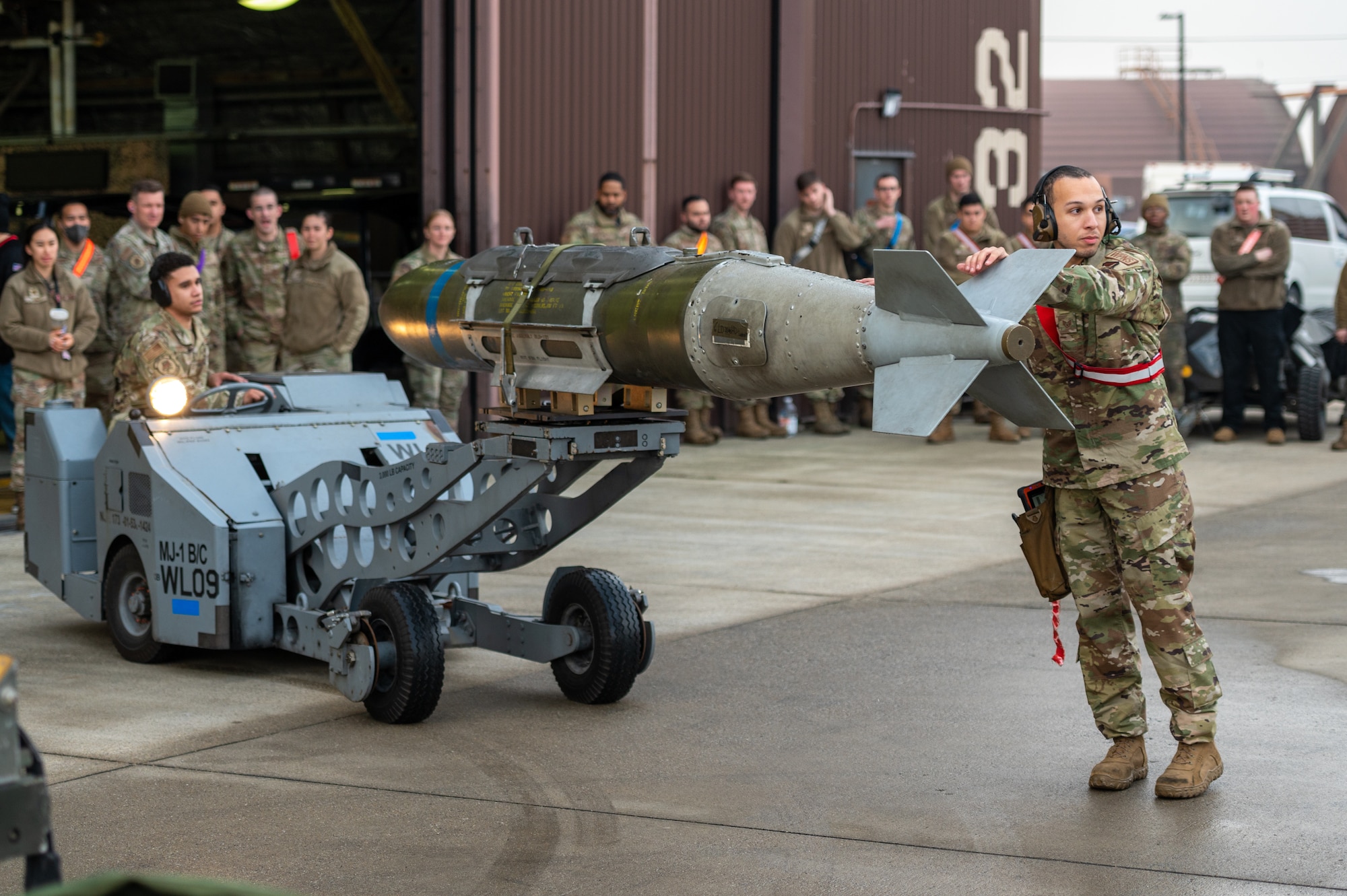 U.S. Air Force Staff Sgt. Anthony Gause, 36th Fighter Generation Squadron weapons load crew team leader, guides a MJ-1C weapons loader carrying a GBU-31V3 munition and driven by USAF Senior Airman Angel Ferrer, 36th Fighter Generation Squadron weapons load crew member, during a weapons load crew of the quarter competition
