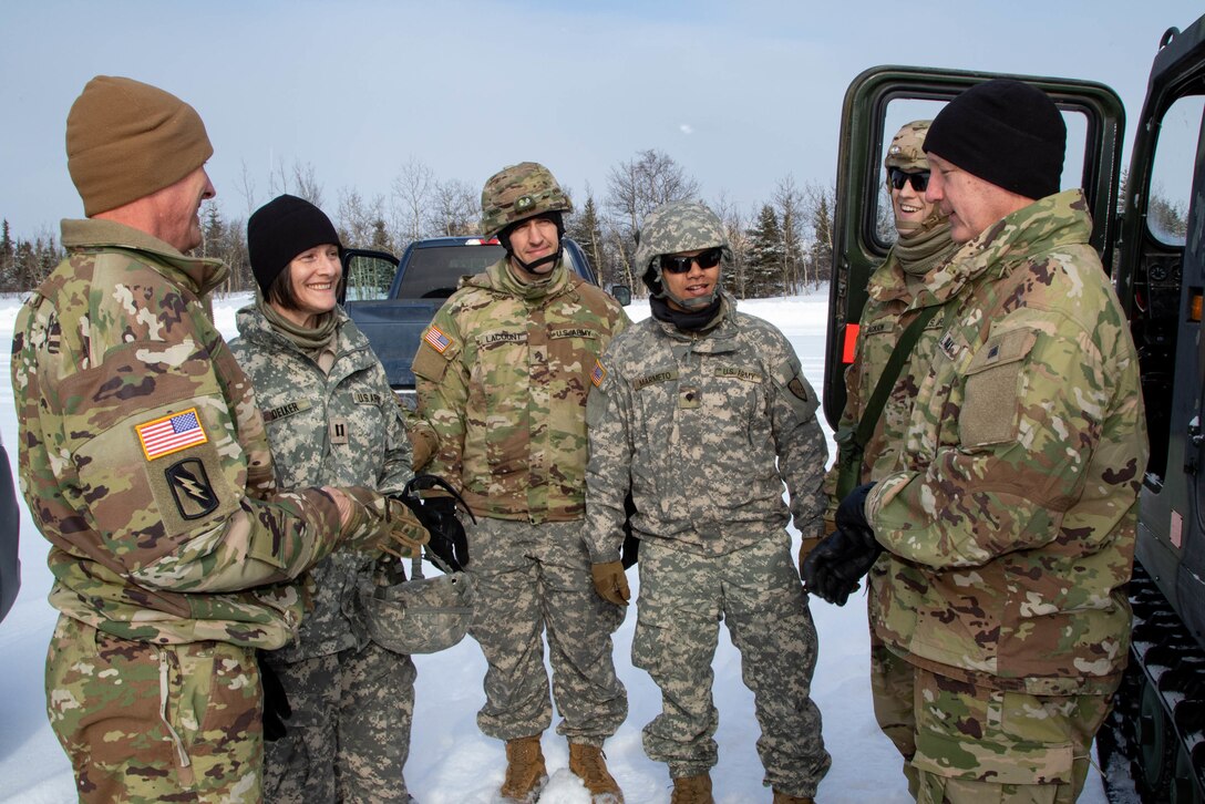 Lt. Gen. Jon A. Jensen, Director, U.S. Army National Guard, far right, and Command Sgt. Maj. John T. Raines, Command Sgt. Maj. of the U.S. Army National Guard, far left, talks to members of 134th Public Affairs Detachment of the Alaska National Guard while visiting the Intermediate Staging Base located near Fort Greely during Joint Pacific Multinational Readiness Center 22-02, March 20. The 134th PAD supported U.S. Army Alaska during one of the largest exercises of the year by providing mass communication specialists who photographed, took video, and wrote articles of U.S. Army Alaska Soldiers during the winter exercise. (Staff Sgt. Christopher B. Dennis/USARAK PAO NCO)