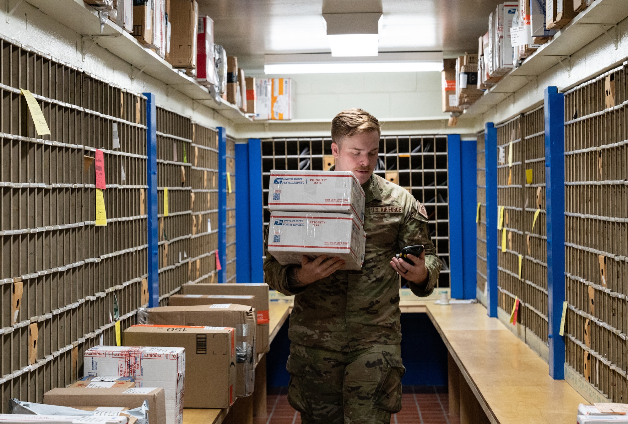 Staff Sgt. Devin Dunlap, 8th Force Support Squadron registered mail NCO in charge, grabs two packages at Kunsan Air Base, Republic of Korea, Nov. 26, 2022. During their holiday operations, the post office receives around 200 parcels weekly and sometimes more; almost three times its usual intake. (U.S. Air Force photo by Staff Sgt. Sadie Colbert)