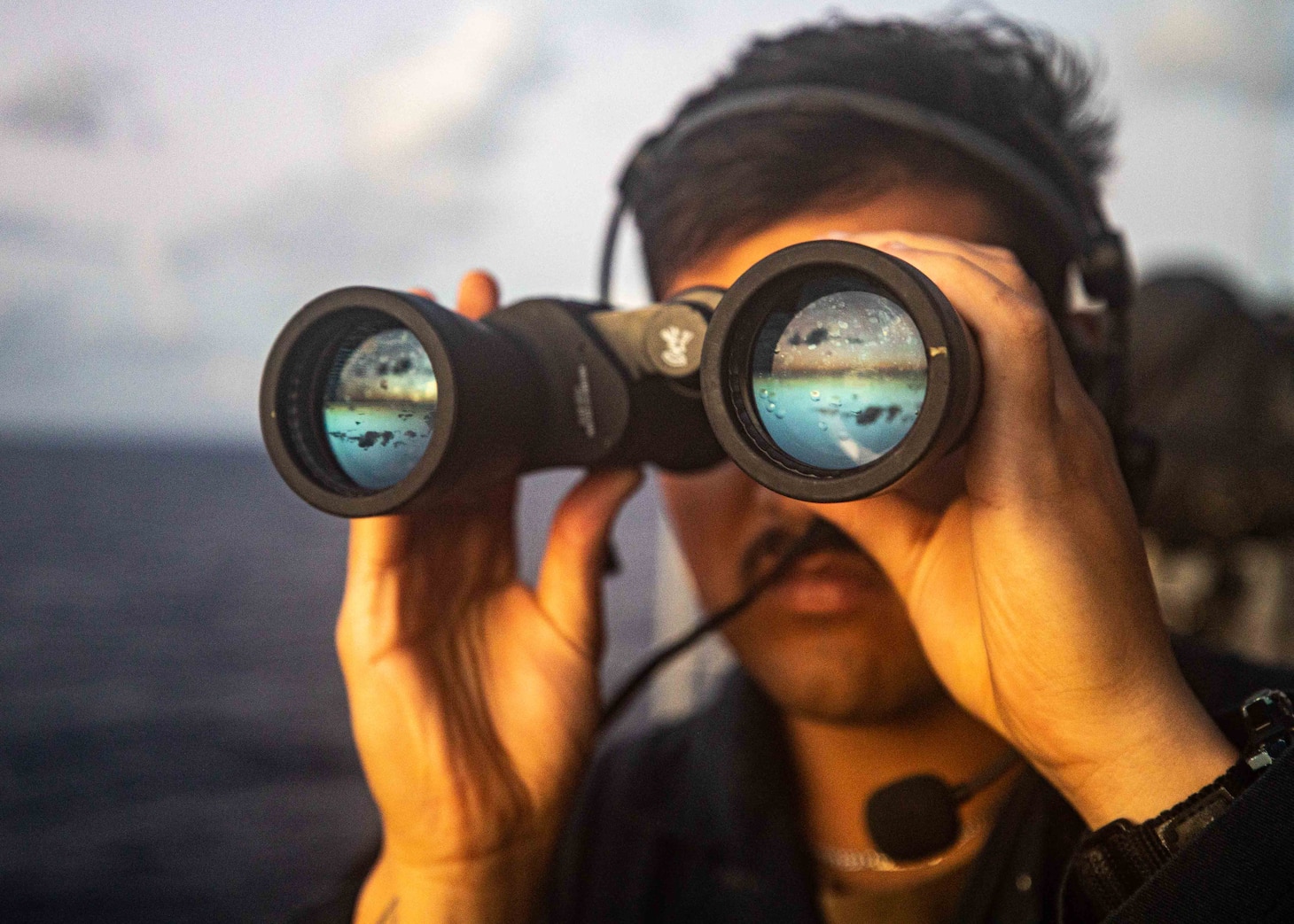 SOUTH CHINA SEA (Nov. 29, 2022) Seaman Robert Torres, from Orlando, Florida, scans for surface contacts on the bridge wing as the Ticonderoga-class guided-missile cruiser USS Chancellorsville (CG 62) conducts routine underway operations in the South China Sea, Nov. 29. Chancellorsville is forward-deployed to the U.S. 7th Fleet area of operations in support of a free and open Indo-Pacific. (U.S. Navy photo by Mass Communication Specialist 2nd Class Justin Stack)