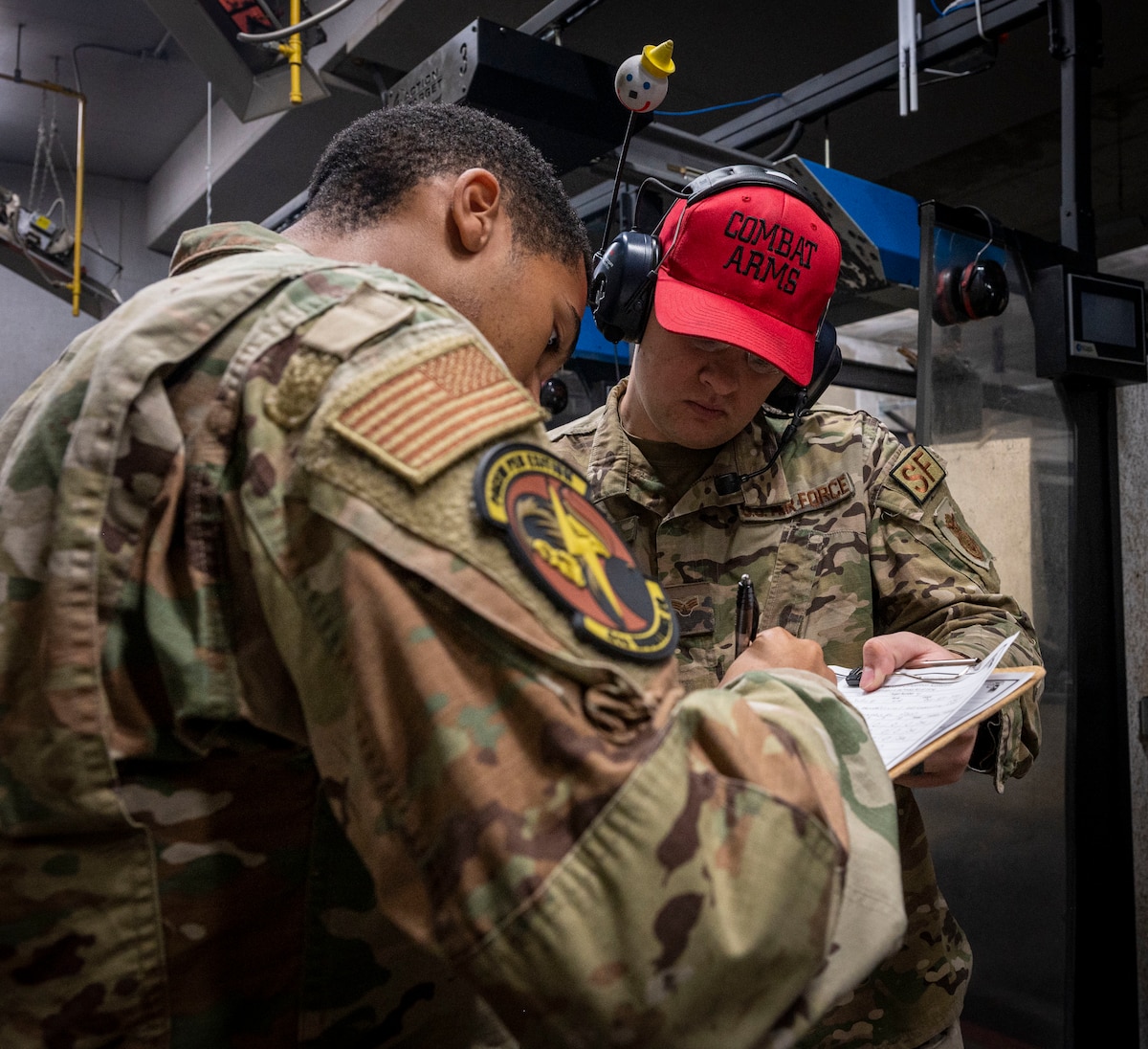 Senior Airman Jaden Edwards (left), 4th Munitions Squadron munitions operations technician, fills out a scorecard with Senior Airman Corely Beck, 4th Security Forces Squadron combat arms training and maintenance instructor, during the excellence-in-competition pistol match at Seymour Johnson Air Force Base, North Carolina, Nov. 18, 2022. The EIC pistol match is a DoD shooting competition, which encourages service members from different career fields to showcase and enhance their skills with the M-9 pistol. (U.S. Air Force photo by Airman 1st Class Sabrina Fuller)