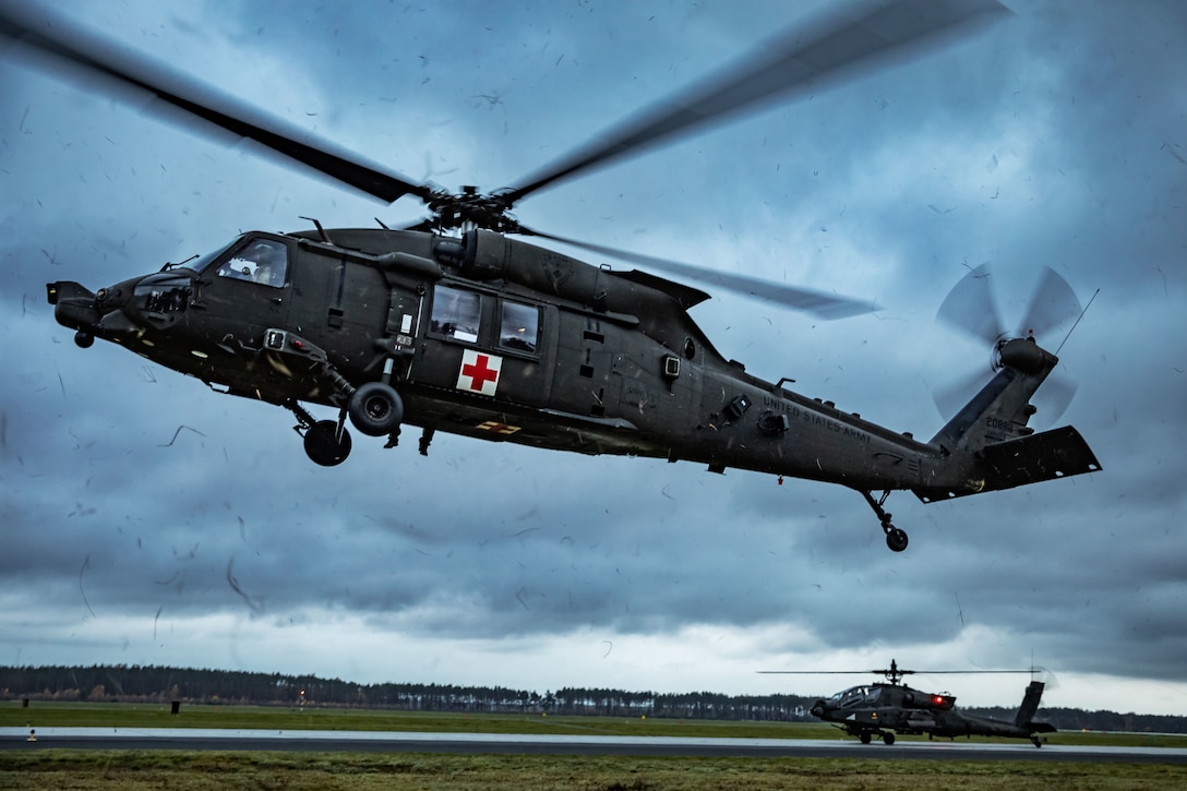 A helicopter hovers during  medical evacuation hoist training.