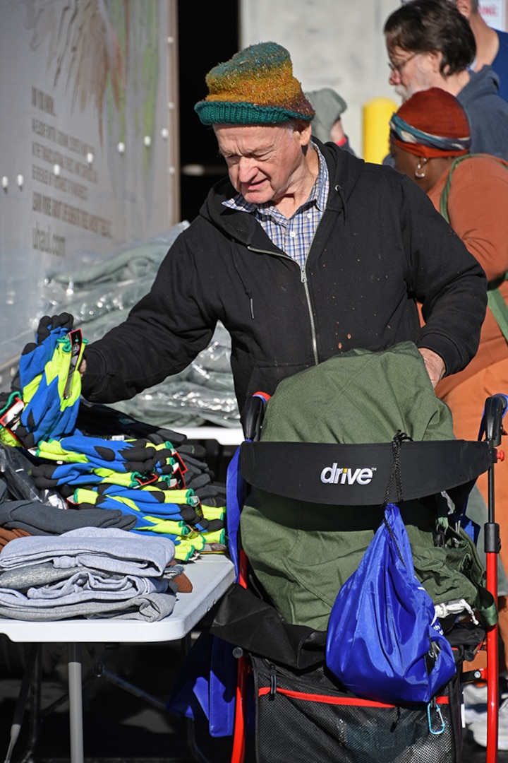 A man looks through a pile of gloves.