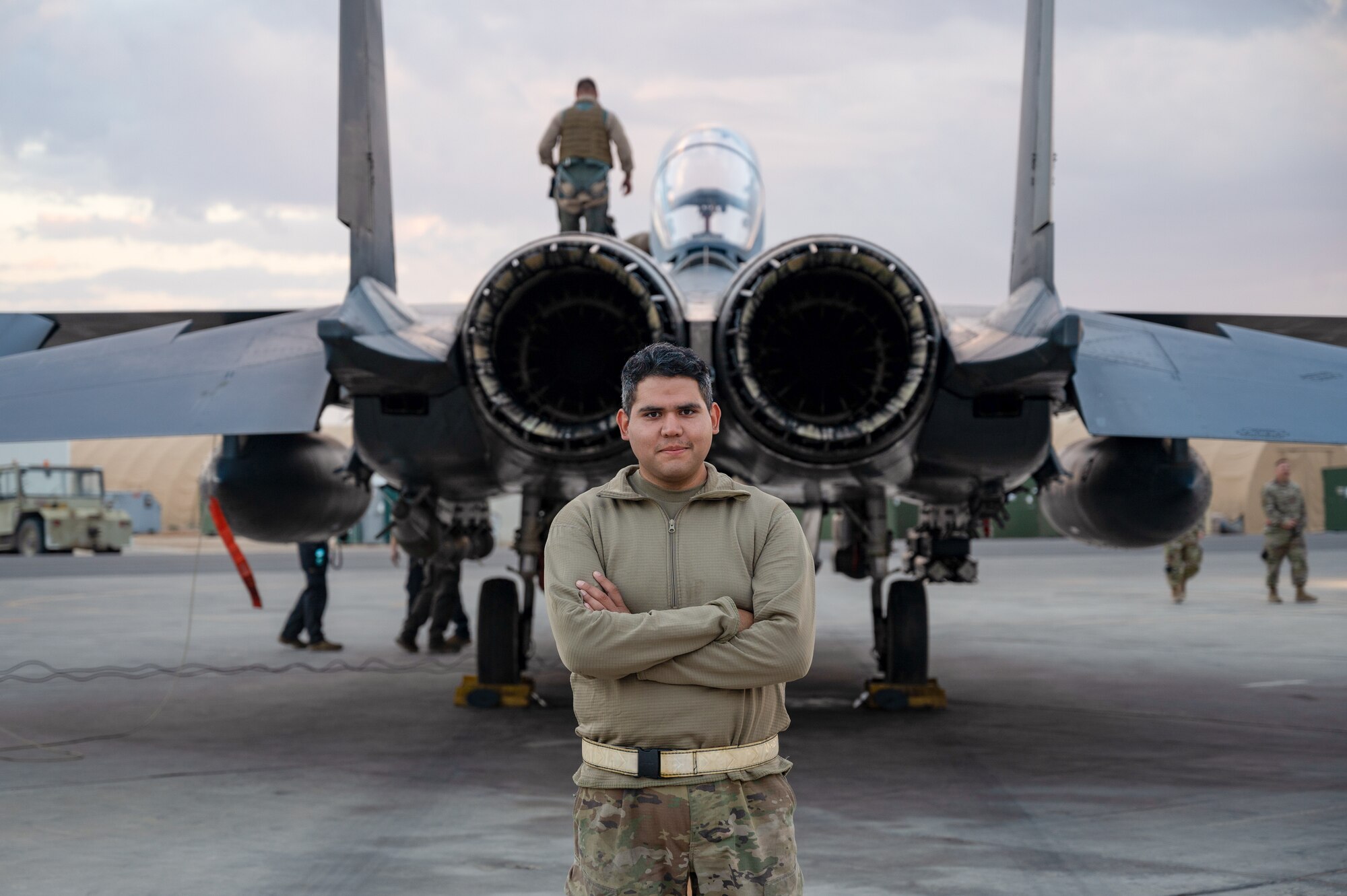 Senior Airman Hector J. Gomez, Jr., Fuels Distribution, 332d Expeditionary Logistics Readiness Squadron Fuels Management Flight, poses behind an F-15E Strike Eagle fighter jet as part of the “Maintainer for a Day” program at an undisclosed location, Nov. 10, 2022. Maintainer for a Day is an initiative that pairs Airmen across the a variety of career fields with members of aircraft maintenance shops for a hands-on learning experience with F-15E Strike Eagle fighter jets. (U.S. Air Force photo by Tech. Sgt. Richard Mekkri)