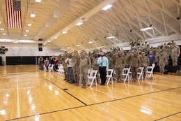 Soldiers and civilians stand during the playing of the national anthem