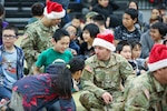 Alaska Army National Guard 2nd Lt. Ryan Montgomery, a pilot with 2nd Battalion, 211th Aviation Regiment (General Support Aviation Battalion), visits with children during Operation Santa Claus in Scammon Bay Nov. 16, 2022.