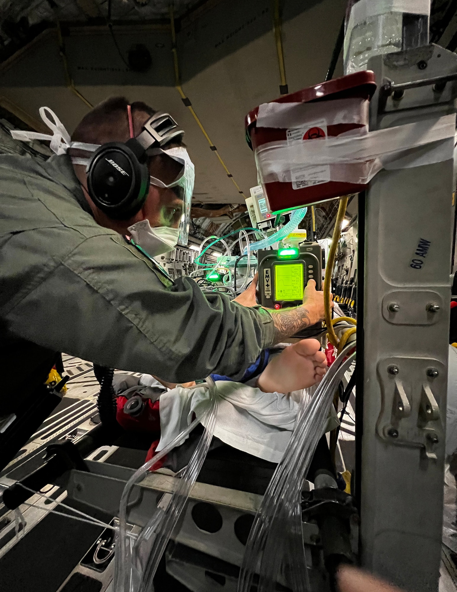 U.S. Air Force Tech. Sgt. Nick Baker, 133rd Medical Group, adjusts a ventilator setting over the skies of the Pacific Ocean, June 25, 2022.