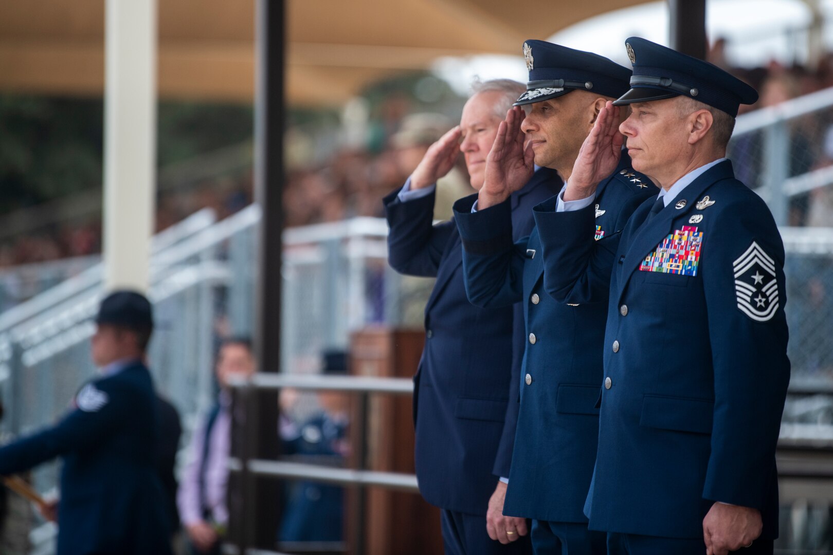 Secretary of the Air Force Frank Kendall, left, salutes the U.S. flag with Lt. Gen. Brian Robinson, center, commander of Air Education and Training Command, and Chief Master Sgt. Erik Thompson, right, AETC command chief, during the playing of the national anthem at the start of a U.S. Air Force Basic Military Training graduation ceremony at Joint Base San Antonio-Lackland, Texas, Nov. 3, 2022