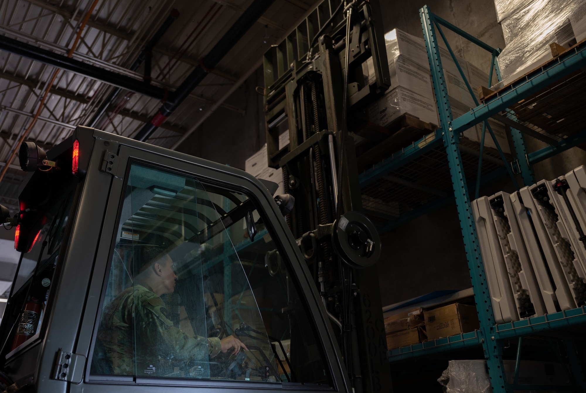 An Airman operates a forklift in a warehouse