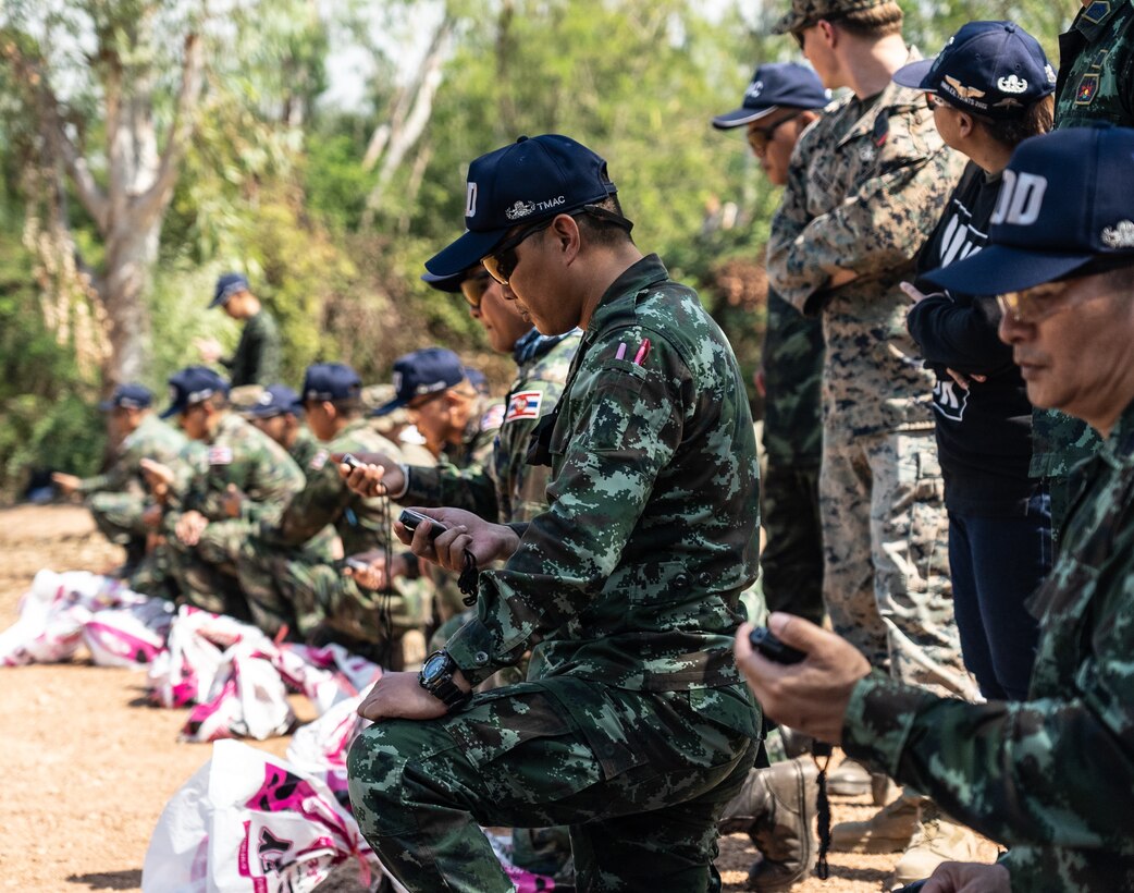 U.S. Marine Corps Humanitarian Mine Action (HMA) Thailand Explosive Ordnance Disposal (EOD) instructors with 3rd EOD Company, 9th Engineer Support Battalion, 3rd Marine Logistics Group, and Thailand Mine Action Center (TMAC) students, track stopwatches until detonation during an EOD level 1-2 course at Jarumanee training area, Ratchaburi, Thailand, November 22, 2022. Royal Thai and American Armed Forces work together to train TMAC students in EOD level 1-2 in order to develop an EOD capacity to assist TMAC’s mission of becoming landmine free. This partnership is aligned with the U.S. Department of Defense’s HMA Program, which assists partnered nations affected by landmines, explosive remnants of war, and the hazardous effects of unexploded ordnance. (U.S. Marine Corps photo by Cpl. Moises Rodriguez)