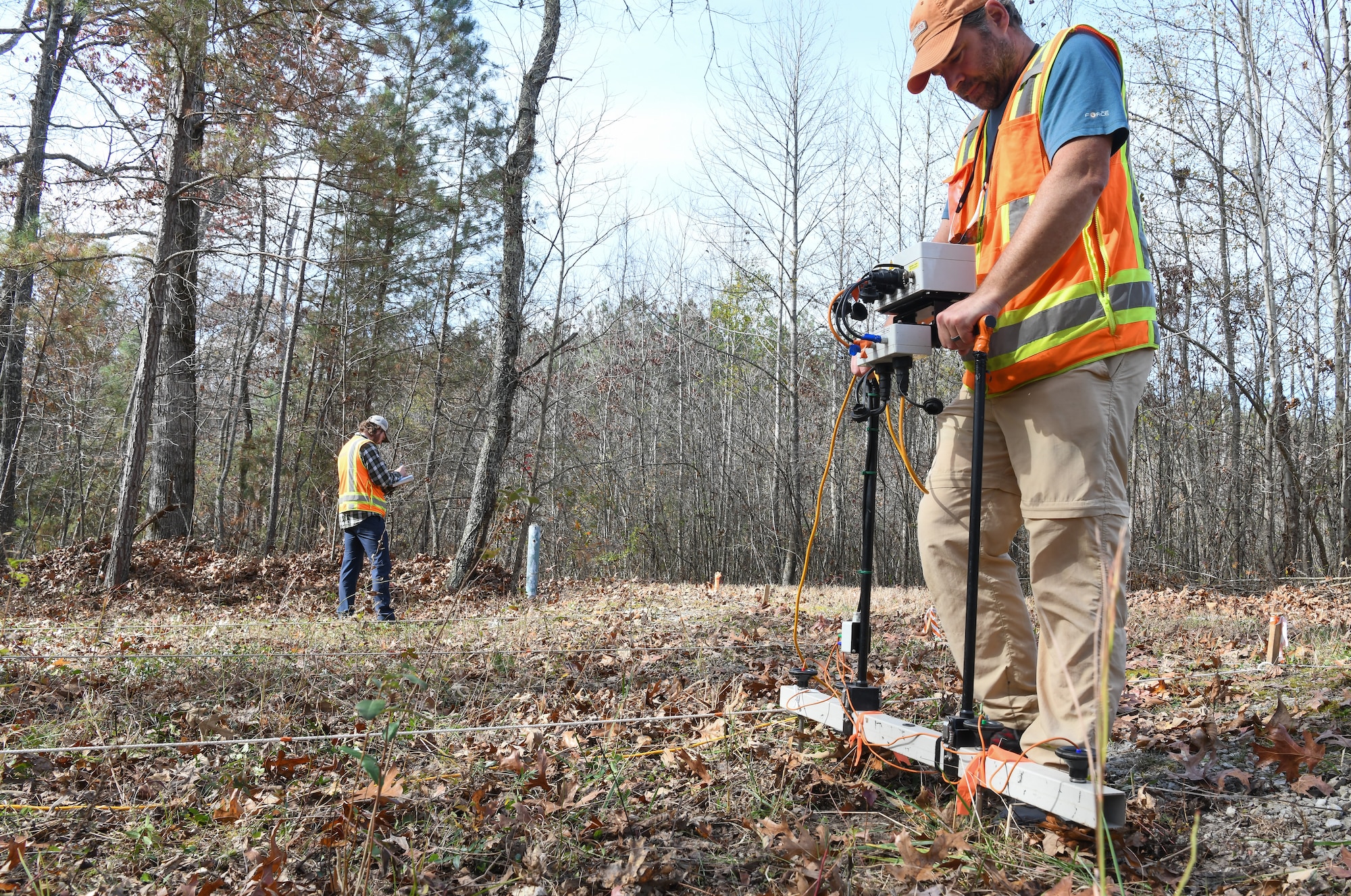 Steve Martin, an archaeologist who specializes in geophysics, uses an electrical resistance meter to survey the Chapel Hill Cemetery at Arnold Air Force Base, Tennessee, Nov. 10, 2022. In the background, Jacob Jepsen, also an archaeologist who specializes in geophysics, begins mapping the cemetery. (U.S. Air Force photo by Jill Pickett)