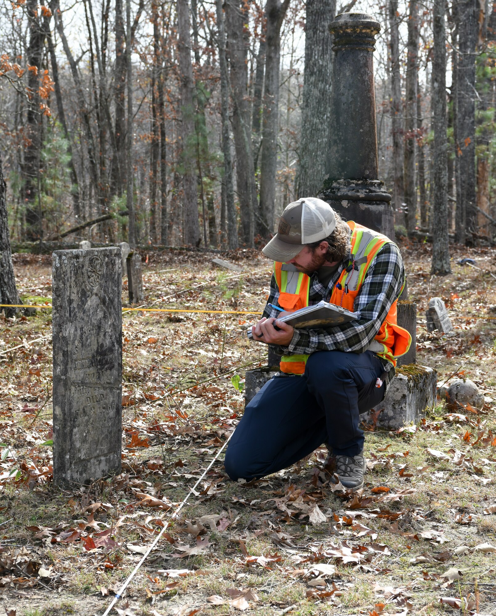 Jacob Jepsen, an archaeologist who specializes in geophysics, looks at one of the grave markers as he maps Chapel Hill Cemetery at Arnold Air Force Base, Tennessee, Nov. 10, 2022. The map is then combined with electrical resistivity and ground penetrating radar data to form a more complete picture of the cemetery. (U.S. Air Force photo by Jill Pickett)
