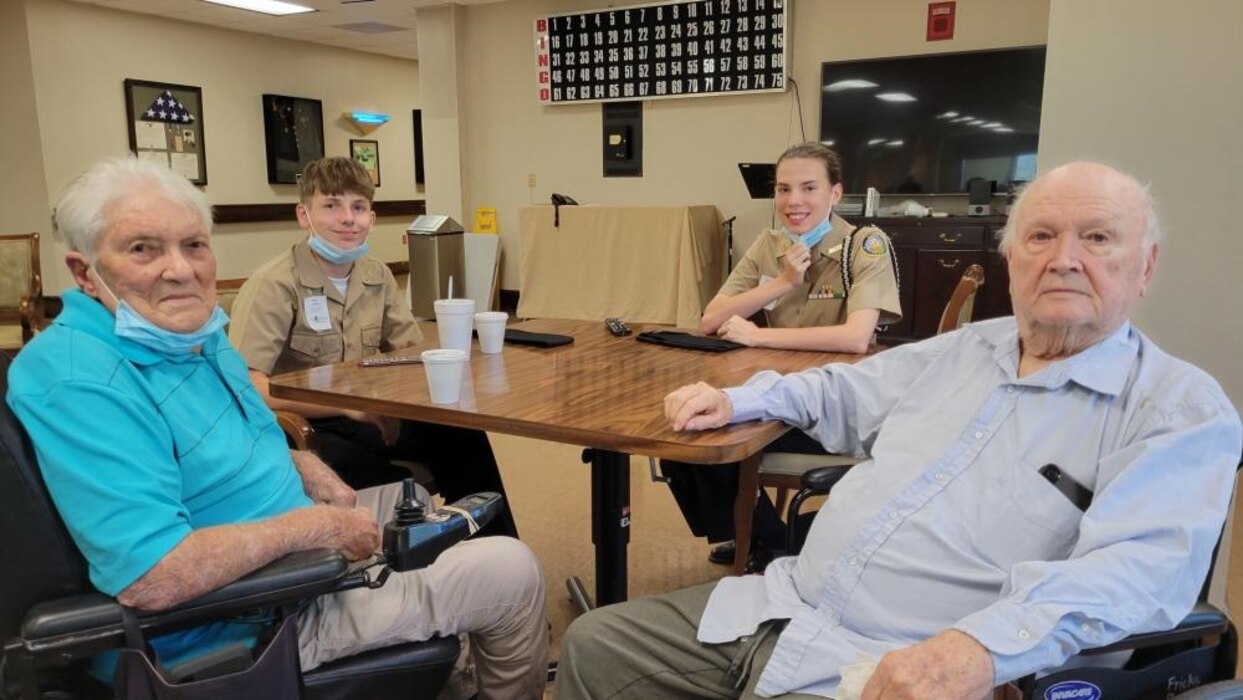 220901-N-LY580-1006 ALEXANDER CITY, Ala. (Sept. 1, 2022) Benjamin Russell High School Navy Junior Reserve Officers Training Corps Cadets Sean Jones (back-left) and Courtney Burgess visit with veterans at Bill Nichols State Veterans Home. (U.S. Navy photo by James Stockman)