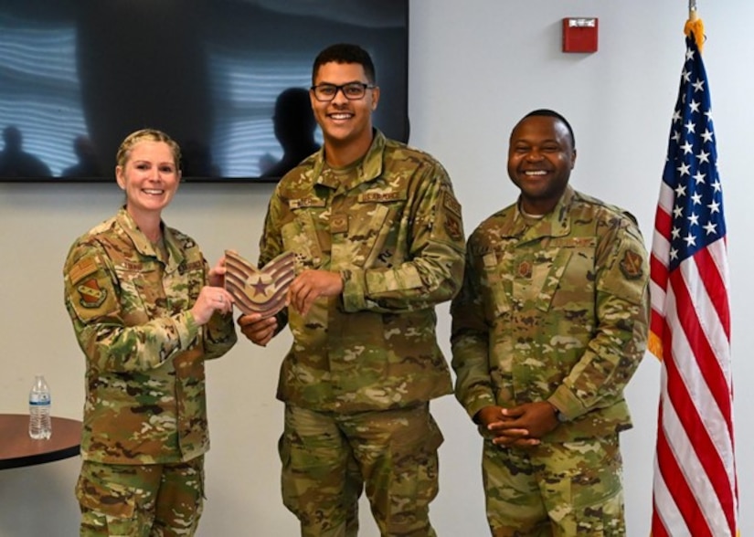 U.S. Air Force Col. Catherine “Cat” Logan, commander of Joint Base Anacostia-Bolling and the 11th Wing, and Chief Master Sgt. Clifford Lawton, senior enlisted leader of JBAB and command chief of the 11 WG, pose for a photo with Tech. Sgt. Brandon Miller, 11th Civil Engineer Squadron power production supervisor, after awarding him a Strips for Exceptional Performers promotion, Nov. 23, 2022, at JBAB, Washington D.C. The STEP program allows commanders an opportunity to immediately promote enlisted Airmen who exhibit exceptional potential beyond their rank. (U.S. Air Force photo by Airman Bill Guilliam)