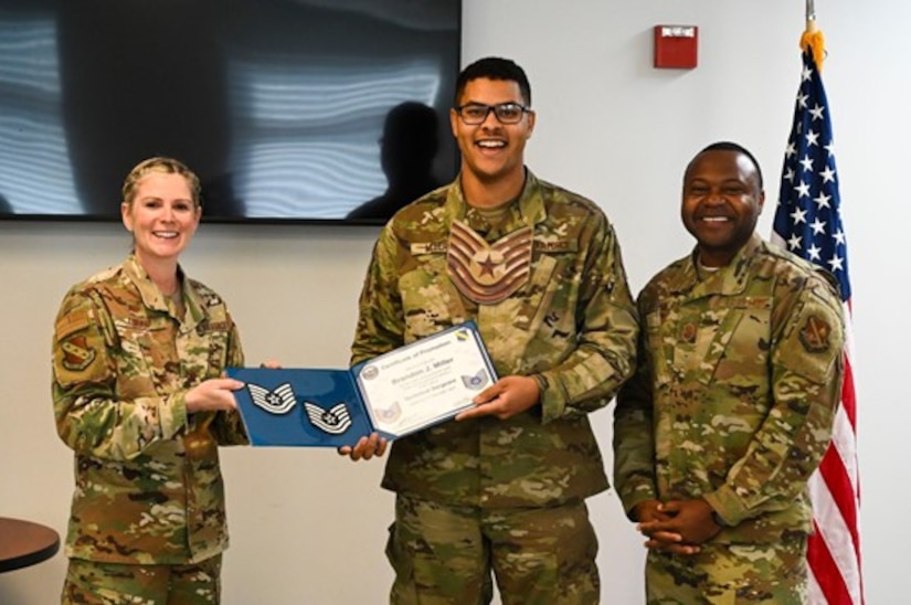 U.S. Air Force Col. Catherine “Cat” Logan, commander of Joint Base Anacostia-Bolling and the 11th Wing, and Chief Master Sgt. Clifford Lawton, senior enlisted leader of JBAB and command chief of the 11th WG, award Tech. Sgt. Brandon Miller, 11th Civil Engineer Squadron power production supervisor, with a certificate for a Strips for Exceptional Performers promotion, Nov. 23, 2022, at JBAB, Washington D.C. The STEP program allows commanders an opportunity to immediately promote enlisted Airmen who exhibit exceptional potential beyond their rank. (U.S. Air Force photo by Airman Bill Guilliam)