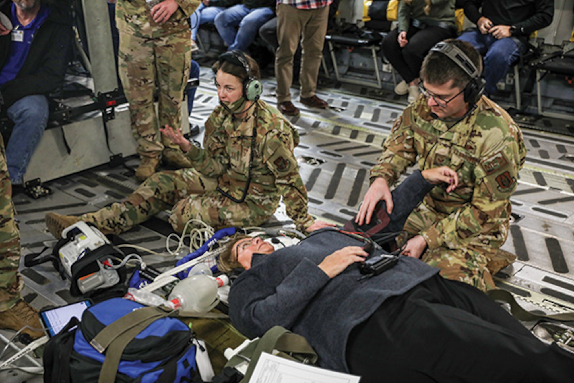 Capt. Emily Perkins, 445th Aeromedical Evacuation Squadron flight nurse and Staff Sgt. Trey Naber, 445th AES technician, demonstrate critical life saving techniques using an employer to role play a patient, during the Bosslift flight onboard a C-17 Globemaster III Nov. 5, 2022. (U.S. Air Force photo/Senior Airman Angela Jackson)