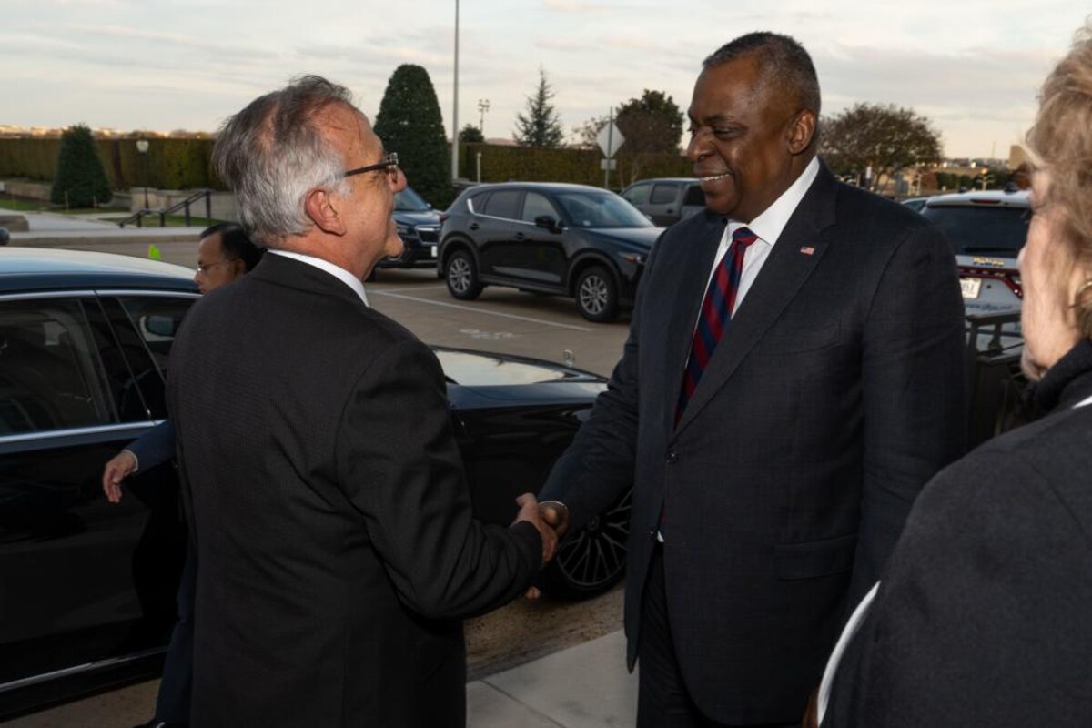 Two men in business attire shake hands.