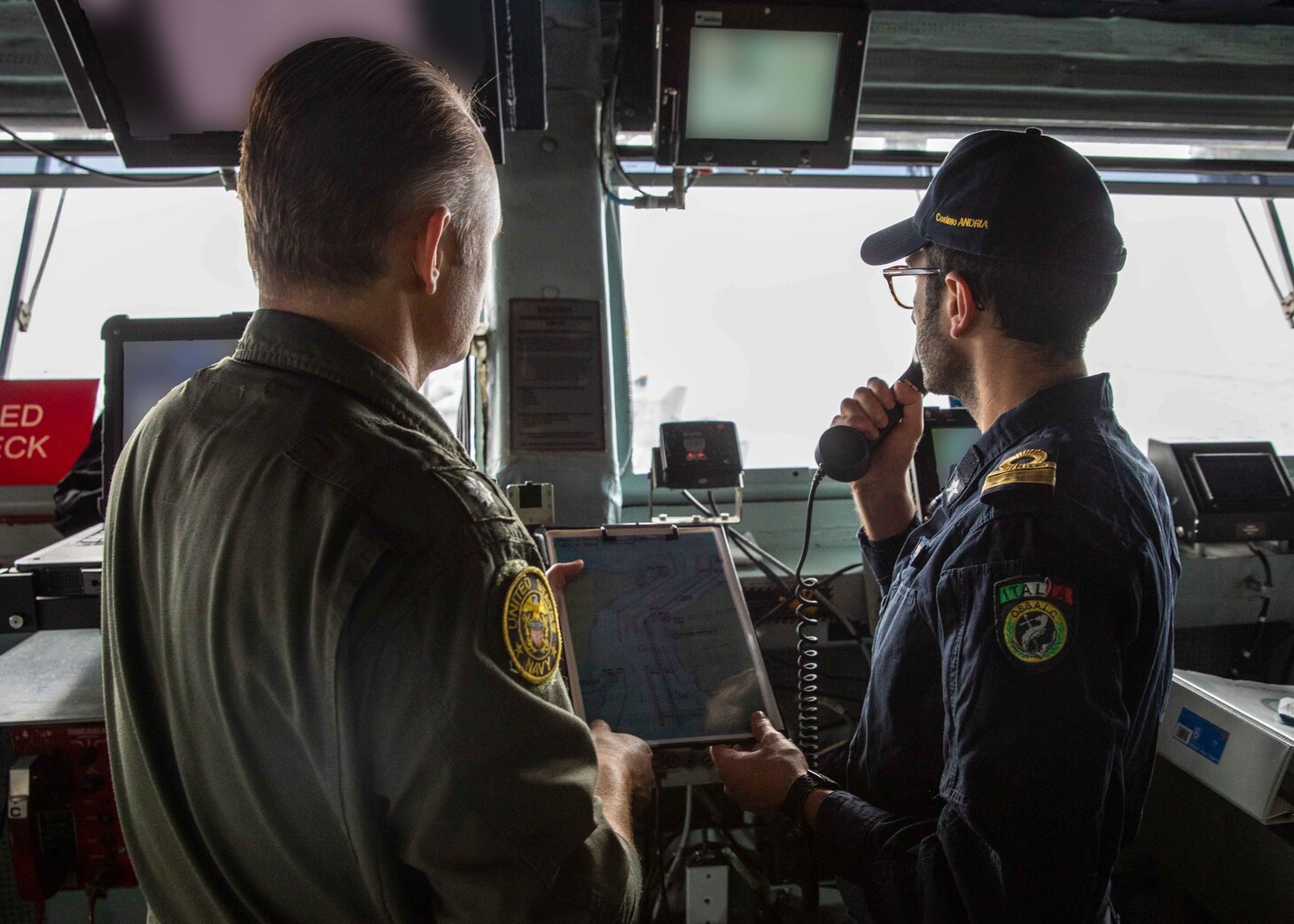 Cmdr. Brian Conlan, navigator of the Nimitz-class aircraft carrier USS George H.W. Bush (CVN 77), and Italian Navy Lt. Cmdr Cosimo Andria, operations officer of the the Italian Navy Carlo Bergamini-class frigate ITS Carabiniere (F 593), plot course of the George H.W. Bush through the Strait of Messina, Nov. 26, 2022.