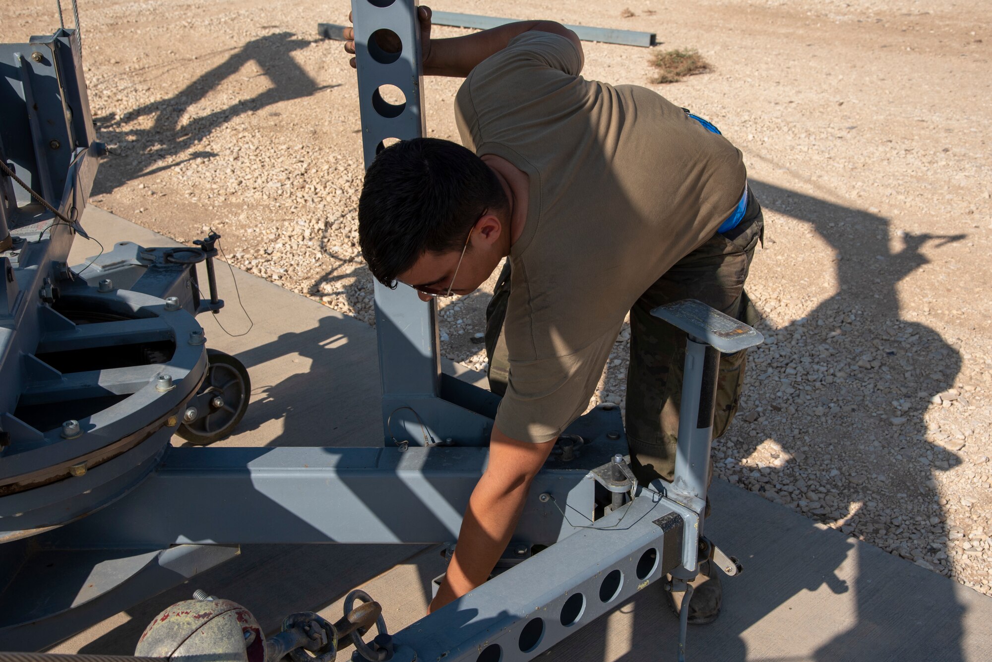 Senior Airman Jacob Karn, an Aerospace Ground Equipment Mechanic with the 332d Expeditionary Maintenance Squadron, turns off the brakes of a canopy crane to prepare it for towing at an undisclosed location, Southwest Asia, Nov. 11, 2022. These cranes are used to remove the canopy and other heavy components of an F-15E Fighting Falcon for repairs. (U.S. Air Force photo by: Tech. Sgt. Jim Bentley)