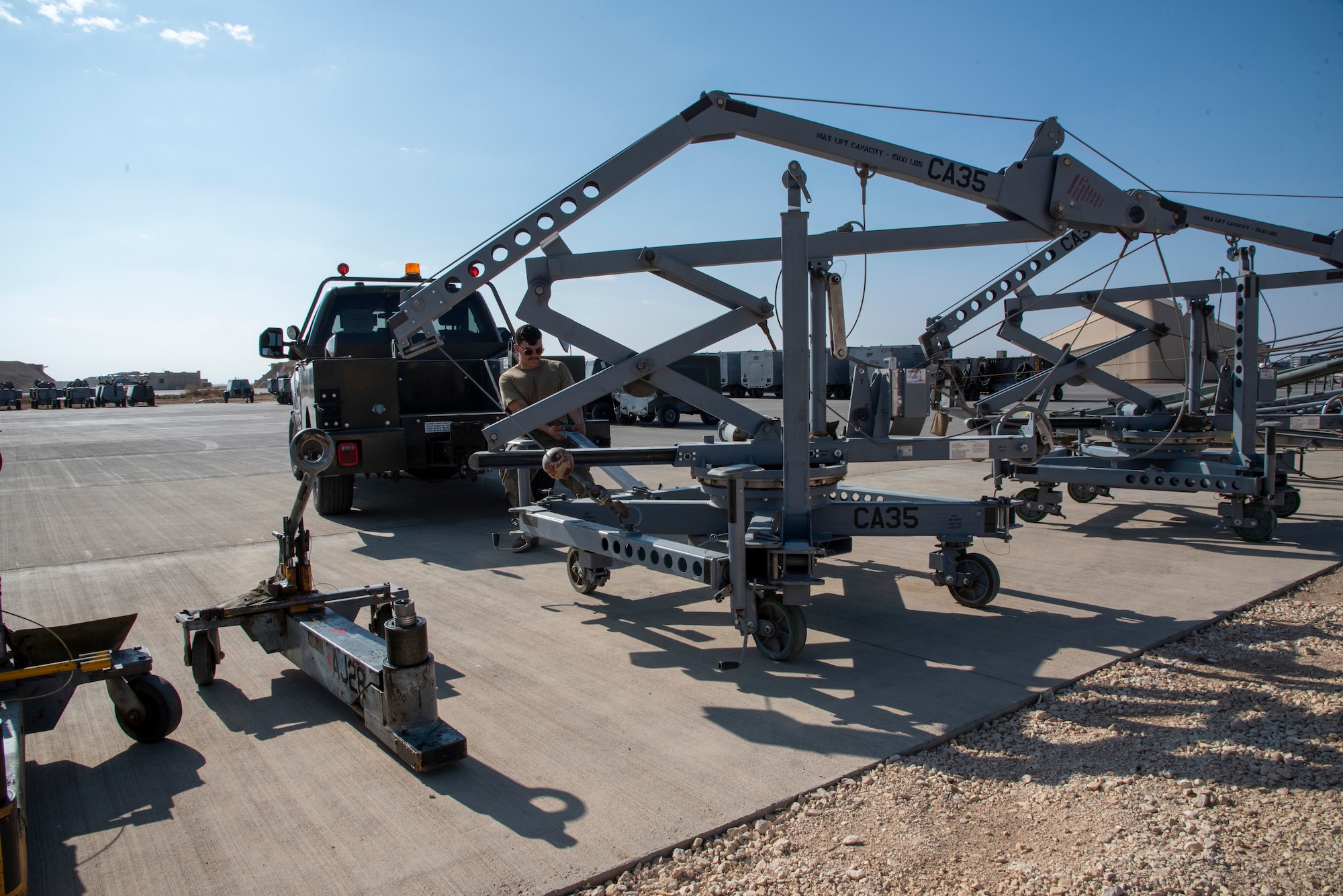 Senior Airman Jacob Karn, an Aerospace Ground Equipment Mechanic with the 332d Expeditionary Maintenance Squadron, pulls a canopy crane at an undisclosed location, Southwest Asia, Nov. 11, 2022.  These cranes are used to remove the canopy and other heavy components of an F-15E Fighting Falcon for repairs. (U.S. Air Force photo by: Tech. Sgt. Jim Bentley)
