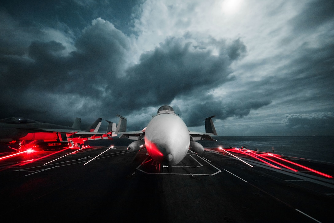 A Super Hornet aircraft sits on a flight deck on an overcast day.