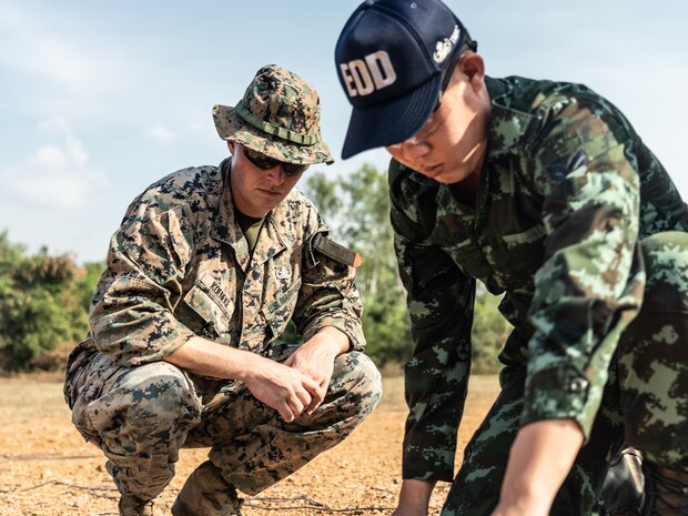 U.S. Marine Corps Sgt. Alex Koeneke, a Humanitarian Mine Action  Thailand Explosive Ordnance Disposal instructor with 3rd EOD Company, 9th Engineer Support Battalion, 3rd Marine Logistics Group, supervises Staff Sgt. Parawut Pongfai, a Thailand Mine Action Center student, during an EOD level 1-2 course at Jarumanee training area, Ratchaburi, Thailand, November 22, 2022. Royal Thai and American Armed Forces work together to train TMAC students in EOD level 1-2 in order to develop an EOD capacity to assist TMAC’s mission of becoming landmine free. This partnership is aligned with the U.S. Department of Defense’s HMA Program, which assists partnered nations affected by landmines, explosive remnants of war, and the hazardous effects of unexploded ordnance.