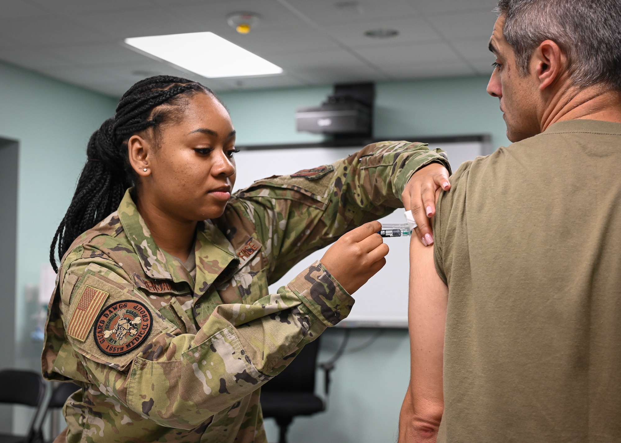 A U.S. Air Force Airman assigned to the 165th Airlift Wing, Georgia National Guard, administers a flu shot to a patient during the fourth annual Physical Health Assessment Rodeo November 4-6, 2022, at the Savannah Combat Readiness Training Center, Savannah, Georgia. The four-day event, hosted during the wing’s November Unit Training Assembly, allowed service members to complete all medical readiness requirements within a one-hour time slot, increasing efficiency and ensuring 165th troops remain worldwide deployable. (U.S. Air National Guard photo by Tech. Sgt. Morgan R. Whitehouse)