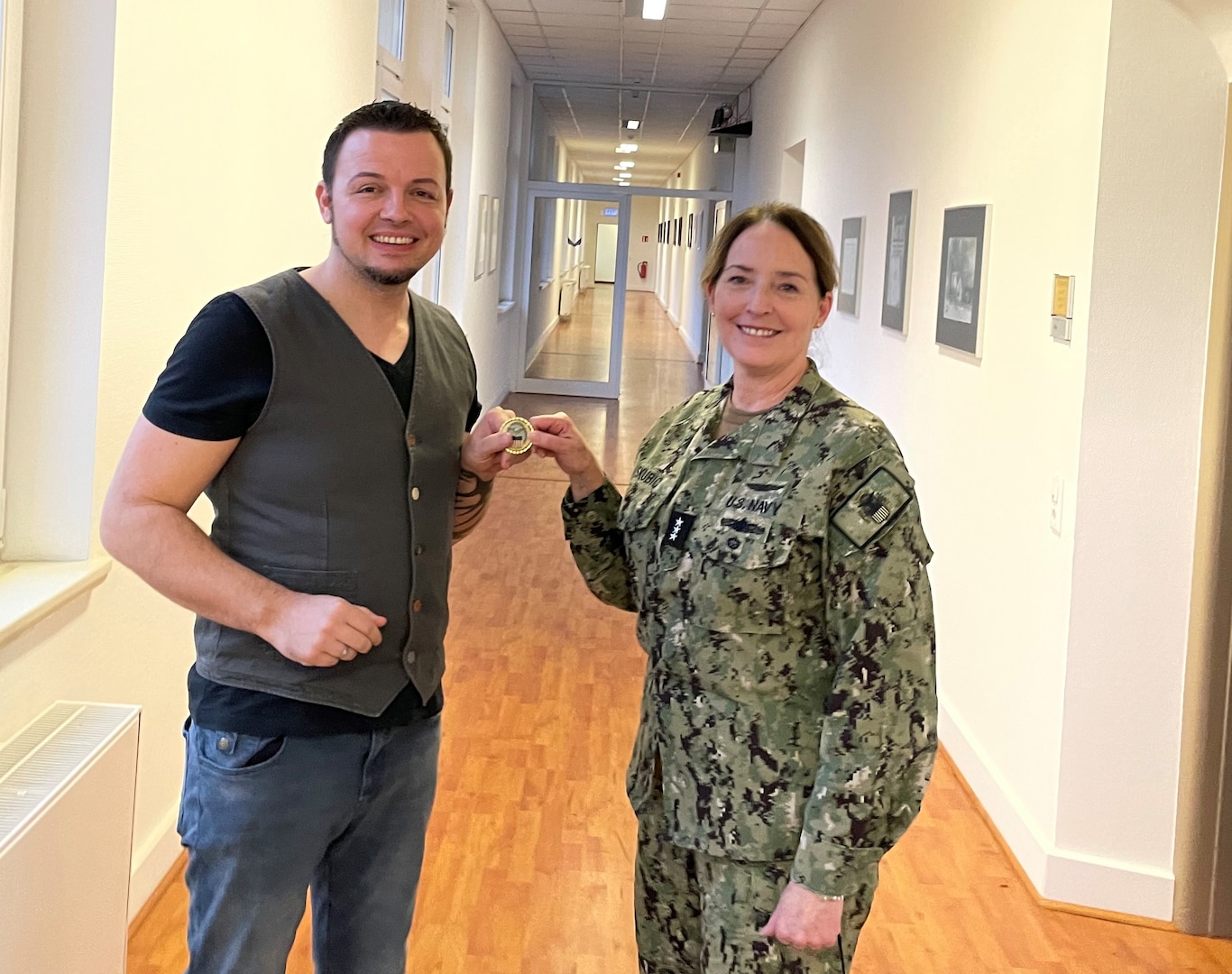 military commander presents civilian employee with a unit coin