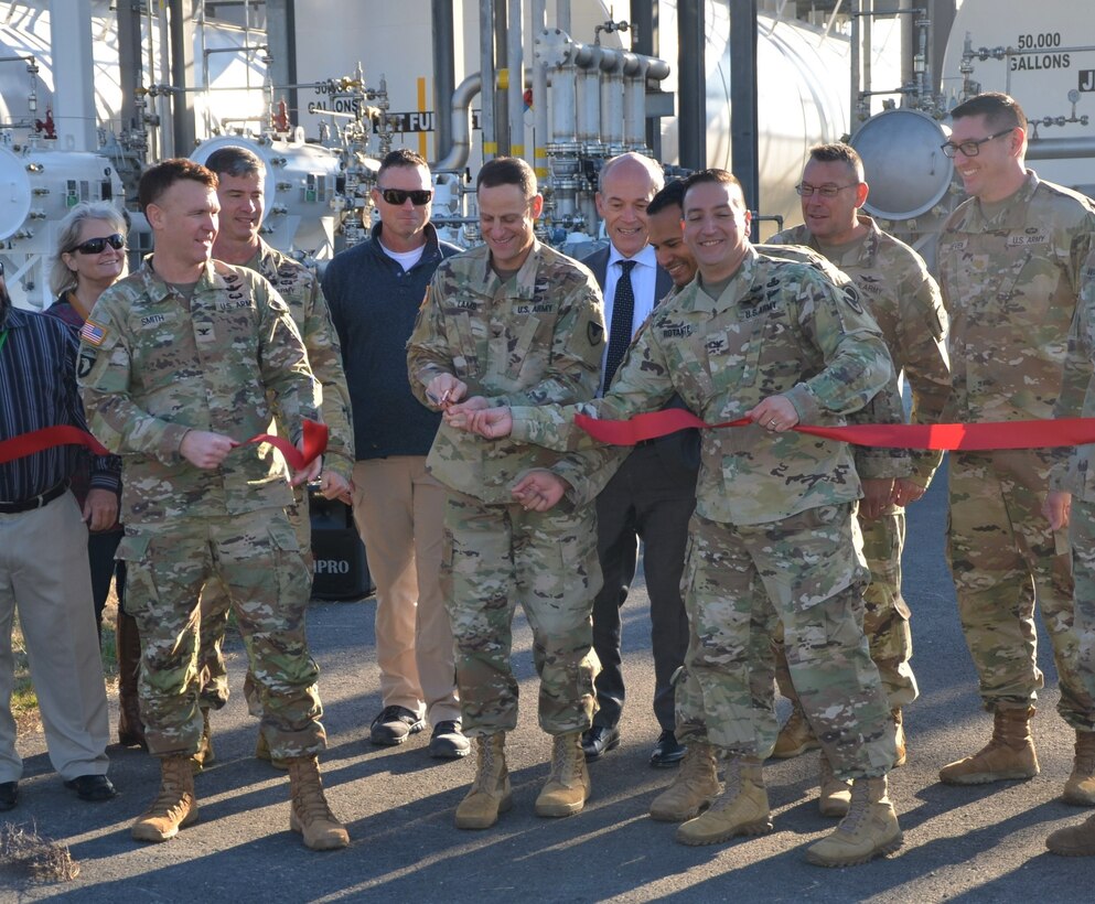 Flanked by key members responsible for the new airfield refueling facility on Gray Army Airfield at Joint Base Lewis-McChord, Col. Phillip Lamb, center, JBLM commander, slices through the ribbon to officially open the facility Nov. 17. (Bud McKay, Joint Base Lewis-McChord Public Affairs)