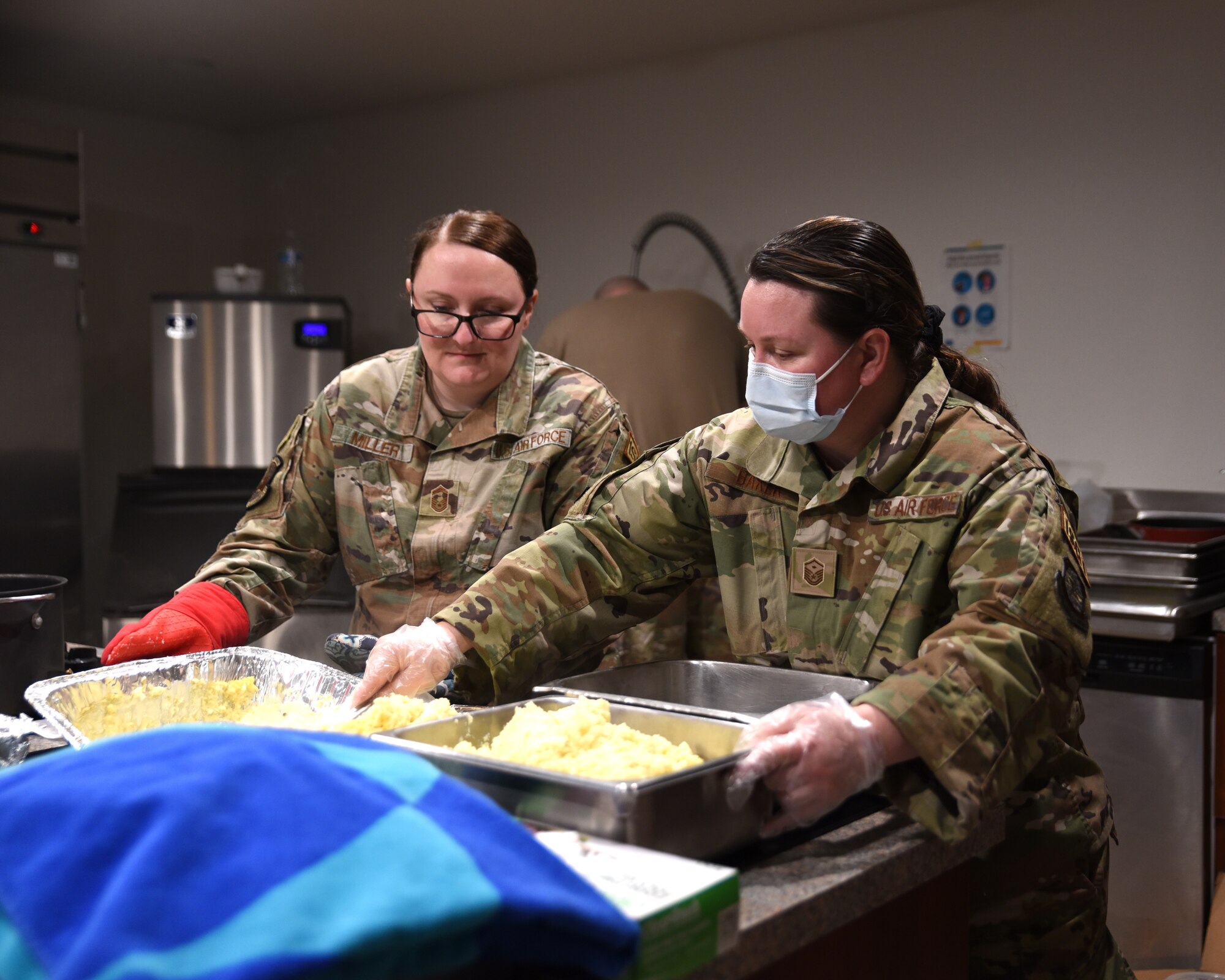 U.S. Air Force Senior Master Sgt. Danielle Miller, left, 627th Logistics Readiness Squadron first sergeant, and Master Sgt. Dalynda Baker, 62d Operations Support Squadron first sergeant, prepare food for the Dormsgiving Extravaganza at Joint Base Lewis-McChord, Washington, Nov. 17, 2022. Team McChord first sergeants hosted this event as a way to thank Airmen for their hard work and dedication to Team McChord. (U.S. Air Force photo by Airman Kylee Tyus)