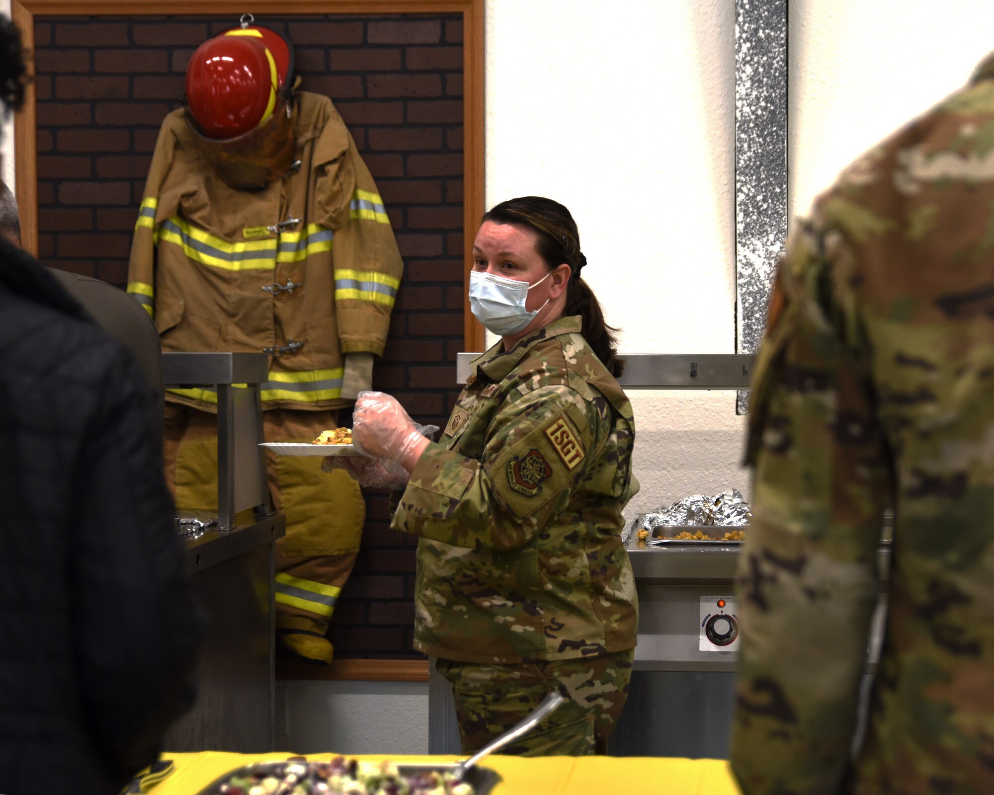 U.S. Air Force Master Sgt. Dalynda Baker, 62d Operations Support Squadron first sergeant, serves food to Team McChord Airmen during the Dormsgiving Extravaganza at Joint Base Lewis-McChord, Washington, Nov. 17, 2022. Team McChord first sergeants hosted this event as a way to thank Airmen for their hard work and dedication to Team McChord. (U.S. Air Force photo by Airman Kylee Tyus)