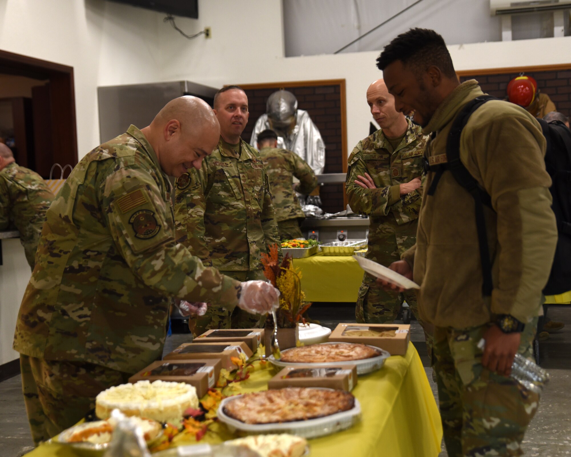 Team McChord first sergeants serve a variety of food during the Dormsgiving Extravaganza at Joint Base Lewis-McChord, Washington, Nov. 17, 2022. Team McChord first sergeants hosted this event as a way to thank Airmen for their hard work and dedication to Team McChord. (U.S. Air Force photo by Airman Kylee Tyus)
