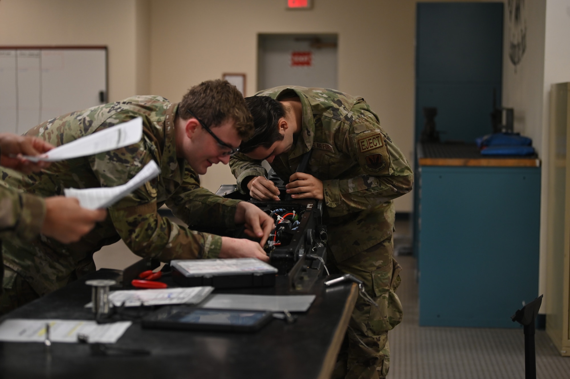 Airman 1st Class Dominic Berning and Airman 1st Class Jesse Herbert, 4th Component Maintenance Squadron egress apprentices, work on an ACES II ejection seat at Seymour Johnson Air Force Base, North Carolina, Nov. 8, 2022. Egress always use a two-man labor concept when working on and inspecting ejection seats. This concept is used to ensure there is nothing missed during repair or inspection. (U.S. Air Force photo by Airman 1st Class Rebecca Sirimarco-Lang)