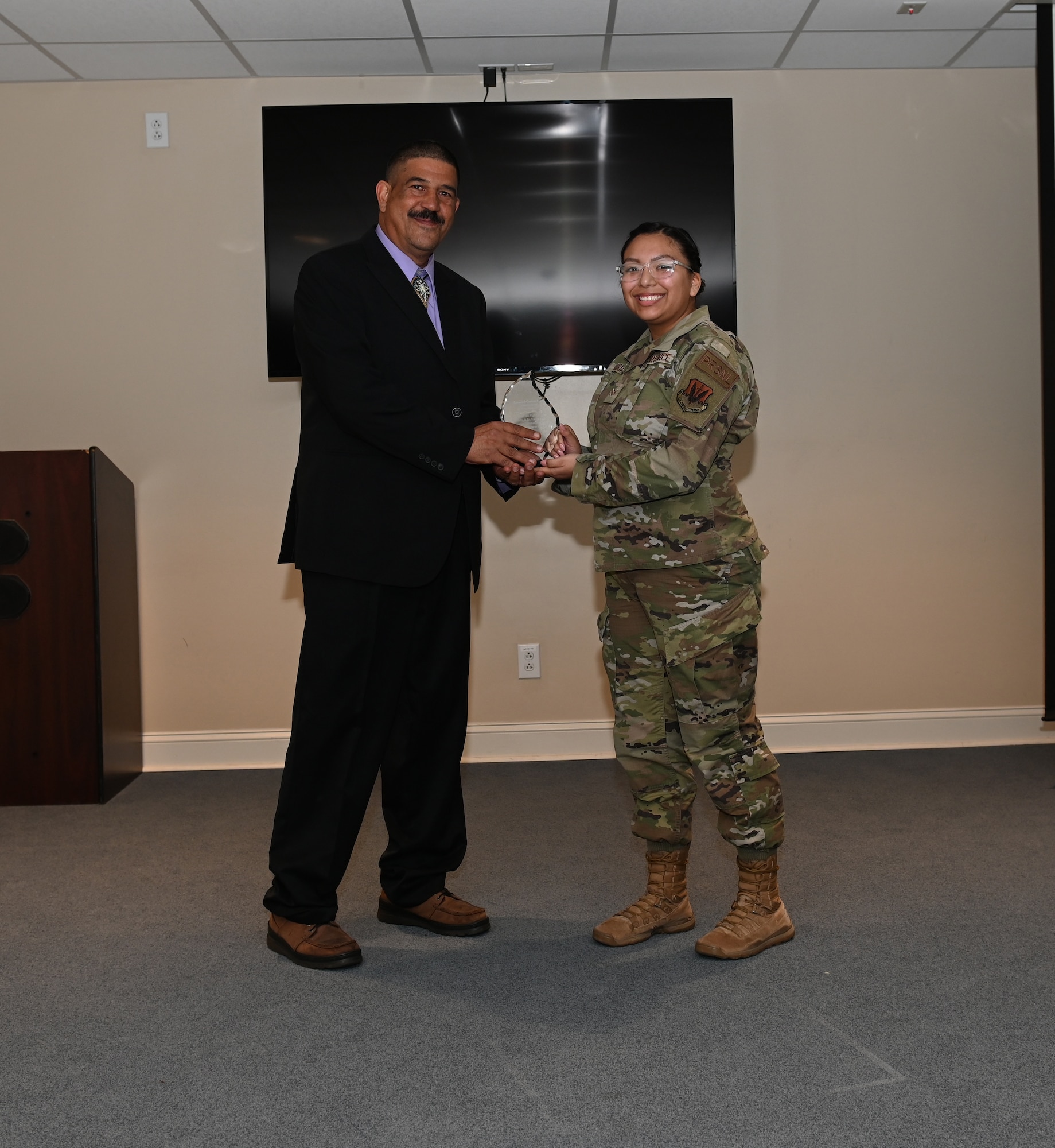 Senior Airman Alyssa Nevaquaya, 4th Operations Support Squadron personnelist, presents Raymond Cochise Clark, disabled combat veteran and Lumbee Tribesman, a gift at the Eagles Landing, at Seymour Johnson Air Force Base, North Carolina, Nov. 22, 2022. Native American Heritage Month is an opportunity to highlight military members who proudly represent the military and their heritage. (U.S. Air Force photo by Airman 1st Class Rebecca Sirimarco-Lang)