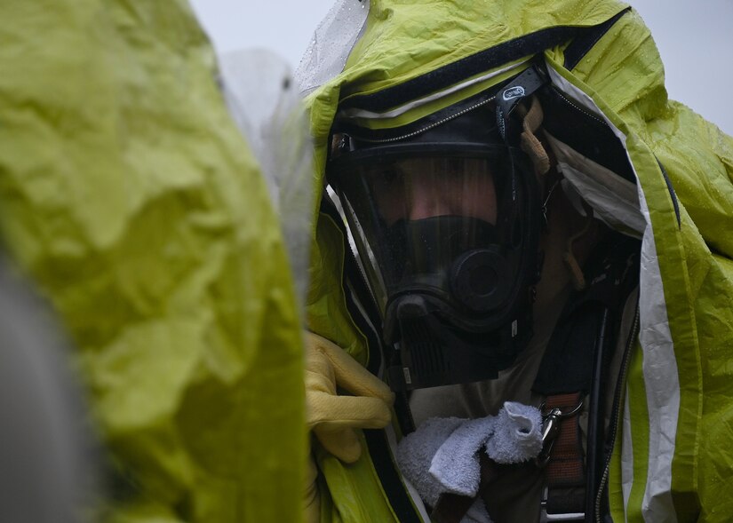 An Airman puts on a gas protection suit in preparation for an active shooter exercise at Joint Base Andrews, Md., Nov. 30, 2022. These types of exercises are typically executed four times a year at JBA to determine if installation personnel and plans are ready for wartime and deployed scenarios. (U.S. Air Force photo by Airman 1st Class Austin Pate)