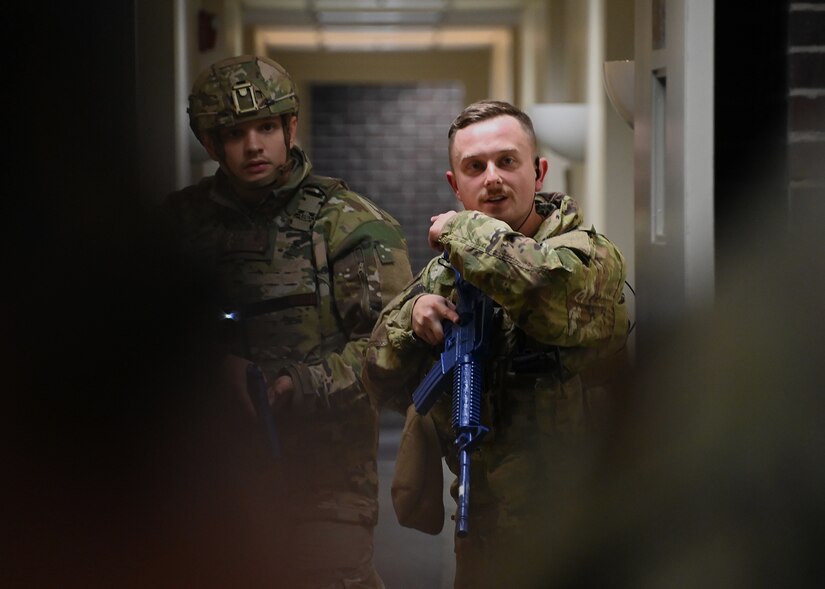 Airmen from the 316th Wing Security Forces Group hold their weapons during an active shooter exercise at Joint Base Andrews, Md., Nov. 30, 2022. During the exercise, Airmen were evaluated on their actions, such as how they communicated with one another, tracked down the target(s) and attempted to save lives. (U.S. Air Force photo by Airman 1st Class Austin Pate)