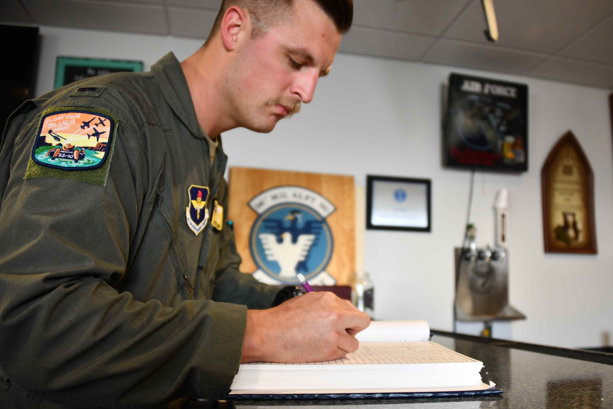 1st Lt. Wyatt Starr, 56th Air Refueling Squadron copilot in training, signs his name in “The Book” at Altus Air Force Base (AFB), Oklahoma, Nov. 3, 2022. It is a tradition for the students to sign their names in this book after their last training flight at Altus AFB. (U.S. Air Force photo by Airman 1st Class Kari Degraffenreed)