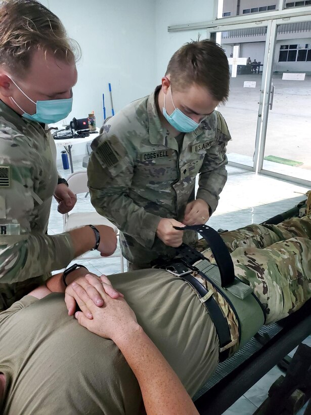 Spc. Dylan Cogswell (center), a medic with Task Force Diamondhead assigned to B Co “Knighthawks,” 2nd Battalion, 25th Aviation Regiment, 25th Infantry Division, teaches Tactical Casualty Combat Care to Sgt. Zachary Harner from C Co “Dustoff,” 2nd Battalion, 25th Aviation Regiment, as part of Exercise Cobra Gold 2022 in the Lopburi Province of the Kingdom of Thailand, March 2, 2022. CG 22 is the 41st iteration of the international training exercise that supports readiness and emphasizes coordination on civic action, humanitarian assistance, and disaster relief. From Feb. 22 through March 4, 2022, this annual event taking place at various locations throughout the Kingdom of Thailand increases the capability, capacity, and interoperability of partnered nations while simultaneously reinforcing our commitment to a free and open Indo-Pacific. (U.S. Army photo by 1st Lt. Jason Palauskas)