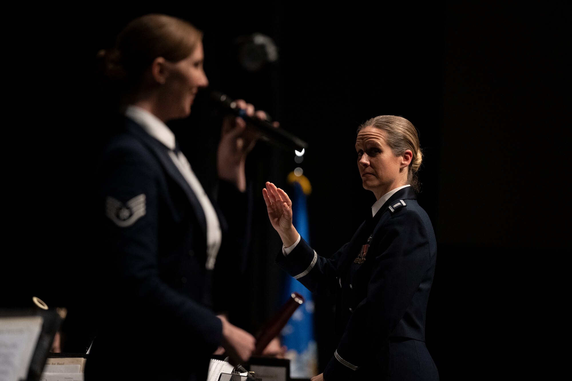 Capt. Christina Muncey, right, United States Air Force Heritage of America Band commander and conductor, conducts the heritage band as Staff Sgt. Rachael Colman, United States Air Force Heritage of America Band vocalist, sings during a Veteran’s Day concert at Edgecombe Community College in Tarboro, North Carolina, Nov. 9, 2022. The Heritage of America Band honors all who have served in the United States Armed Forces by commemorating the contributions of the nation's veterans; past and present, both at home and in deployed locations around the world. (U.S. Air Force photo by Senior Airman Kevin Holloway)