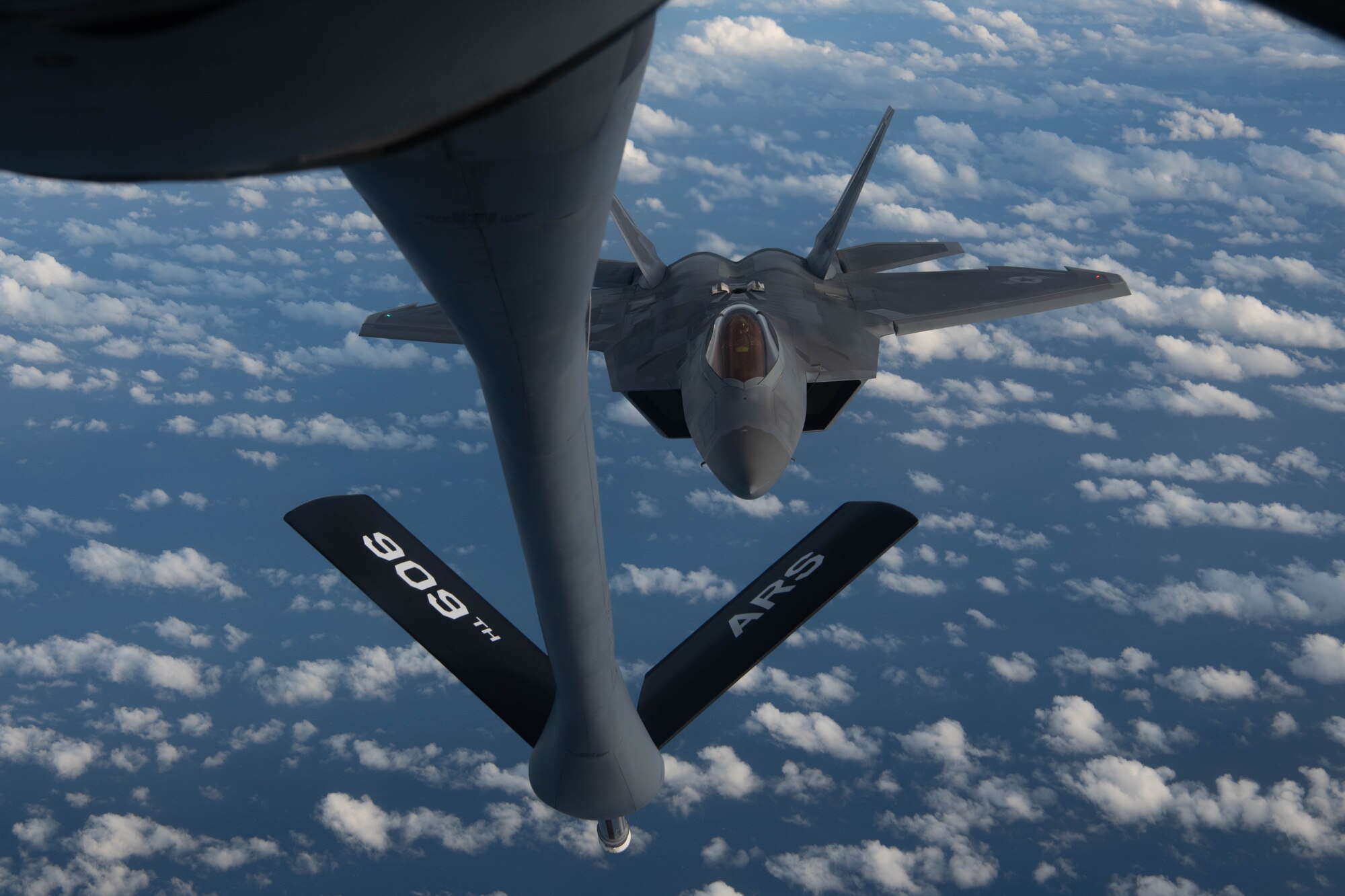 A jet gets refueled in the air.