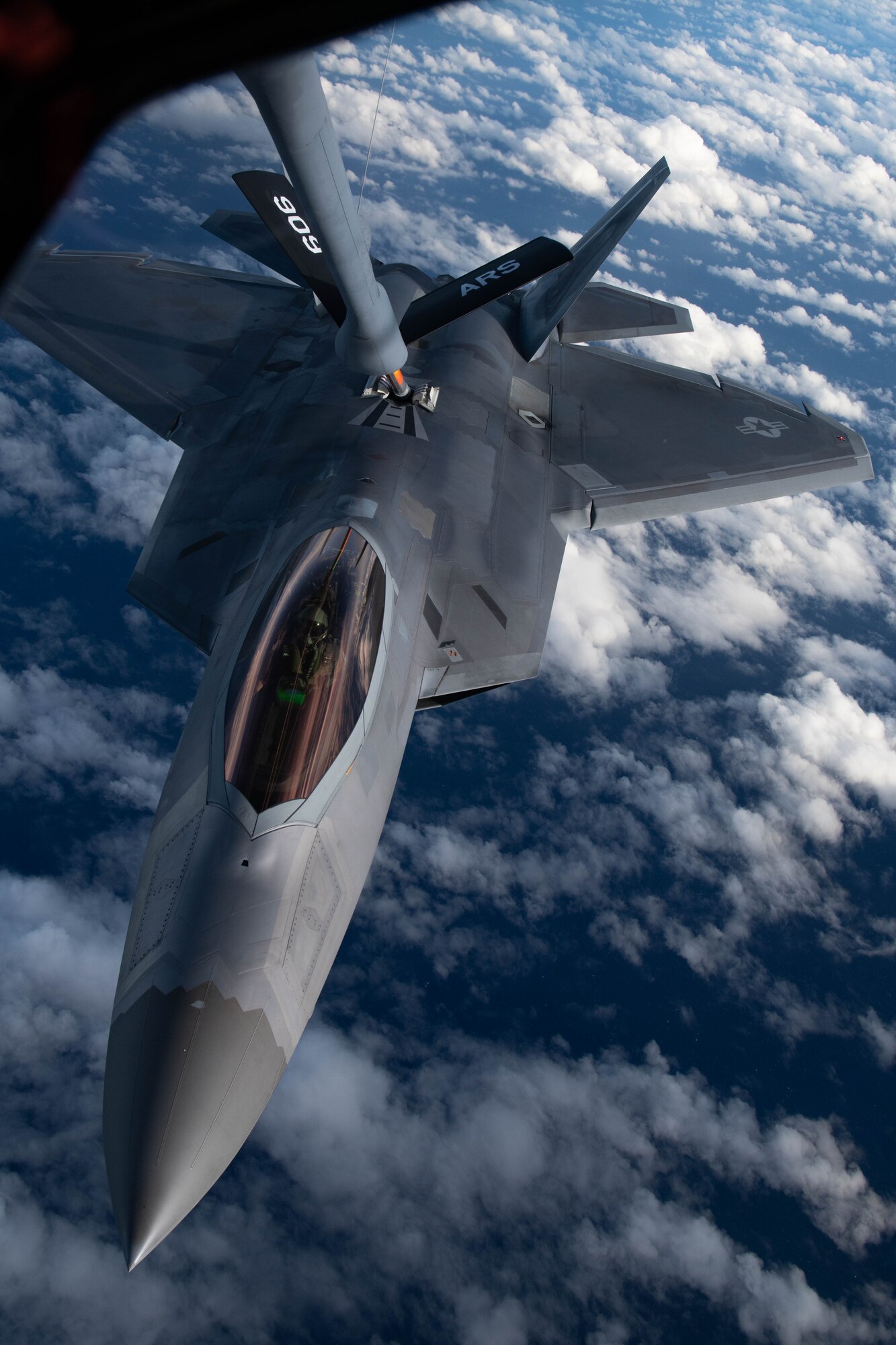 A jet gets refueled in the air.
