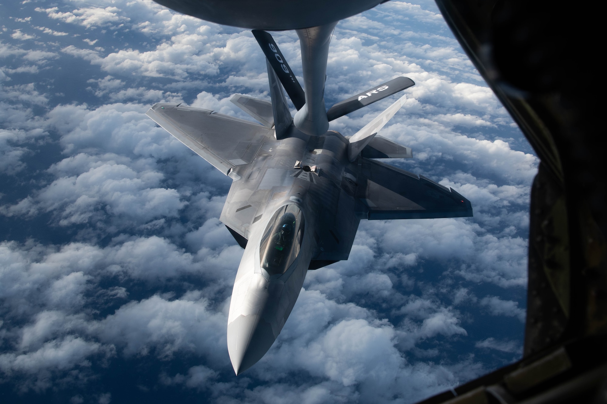 A jet gets refueled in the air.