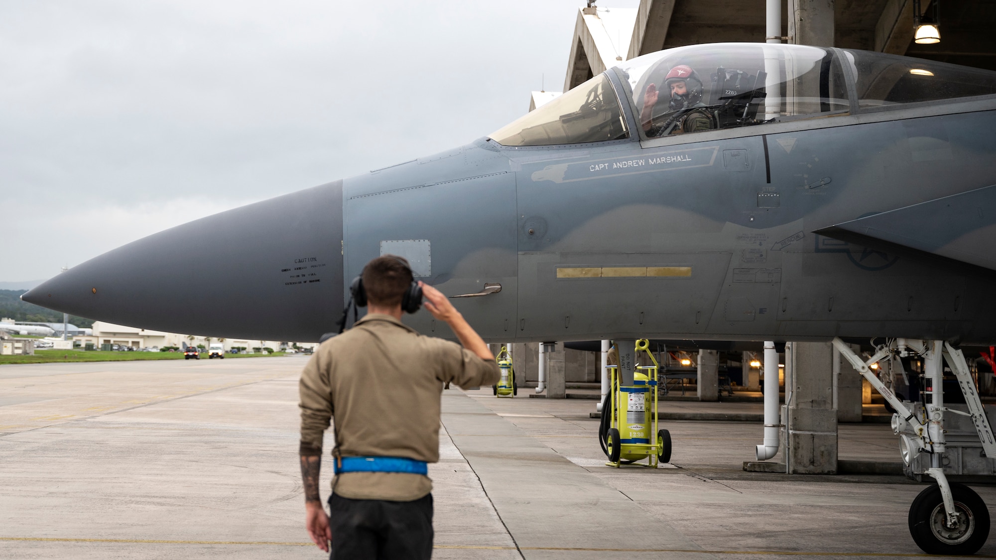 A U.S. Air Force crew chief assigned to the 44th Aircraft Maintenance Unit salutes an F-15C Eagle pilot as he taxis onto the flightline at Kadena Air Base, Japan, Dec. 1, 2022. The 18th Wing bid farewell to several aircraft during the first part of the Eagles' phased withdrawal. (U.S. Air Force photo by Senior Airman Jessi Roth)