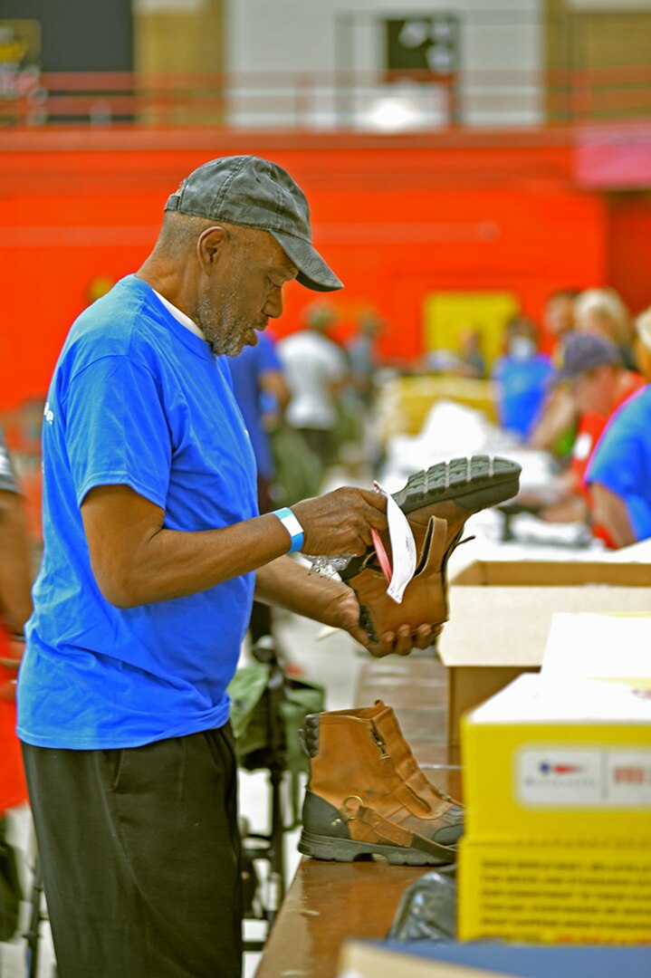 A man looks at a pair of surplus military boots.