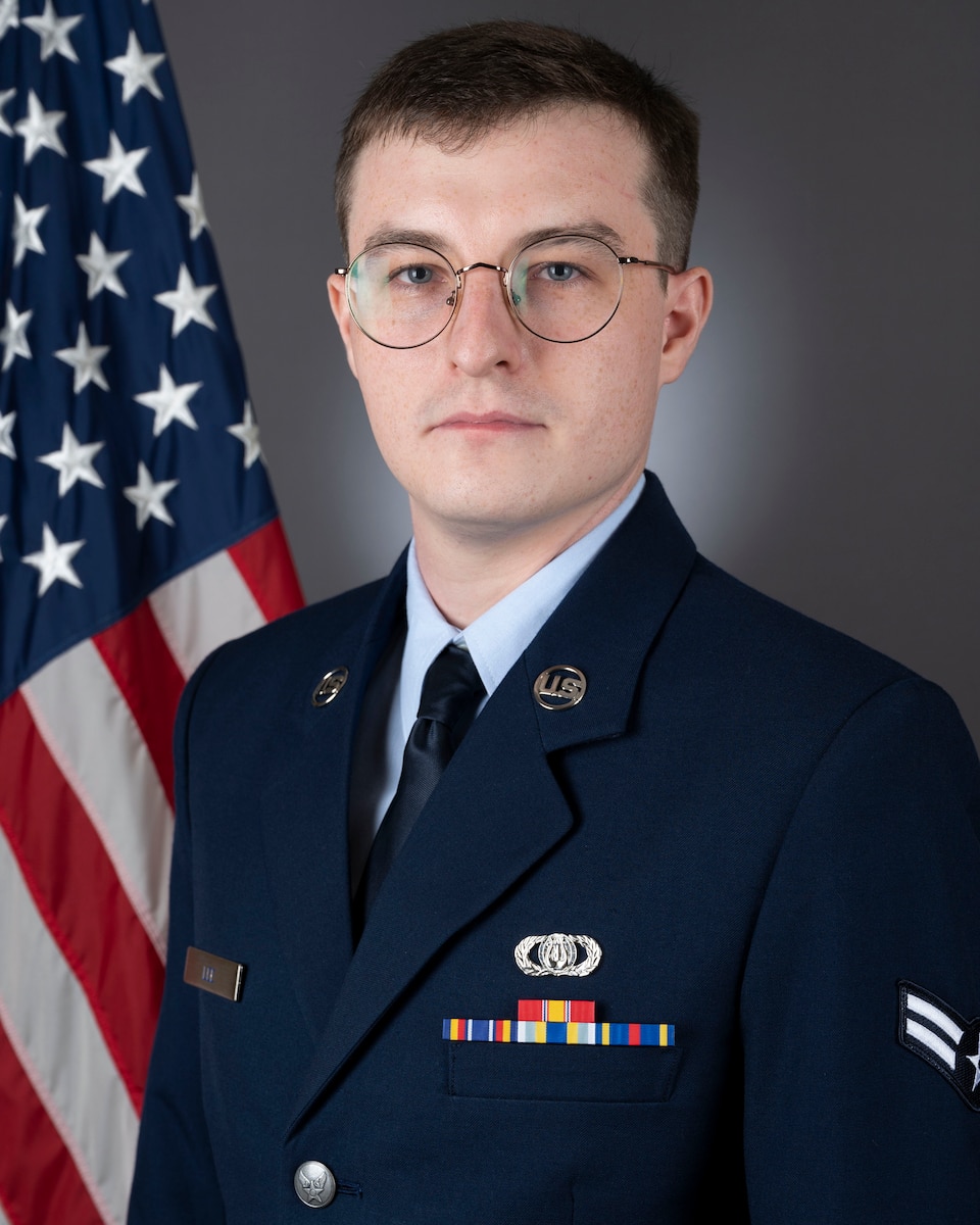 Official photo of A1C Pearse Lee in front of the American flag. He is wearing the blue service dress uniform.