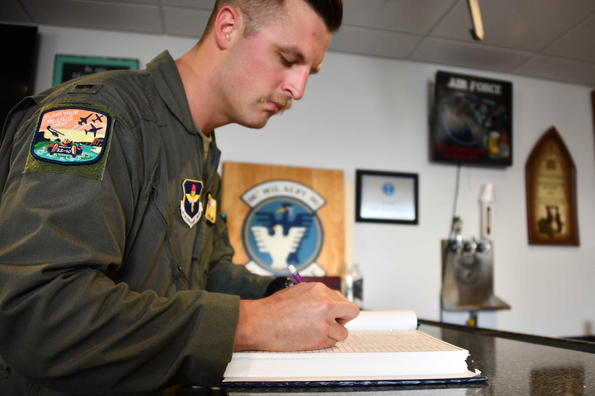 1st Lt. Wyatt Starr, 56th Air Refueling Squadron copilot in training, signs his name in “The Book” at Altus Air Force Base (AFB), Oklahoma, Nov. 3, 2022. It is a tradition for the students to sign their names in this book after their last training flight at Altus AFB. (U.S. Air Force photo by Airman 1st Class Kari Degraffenreed)