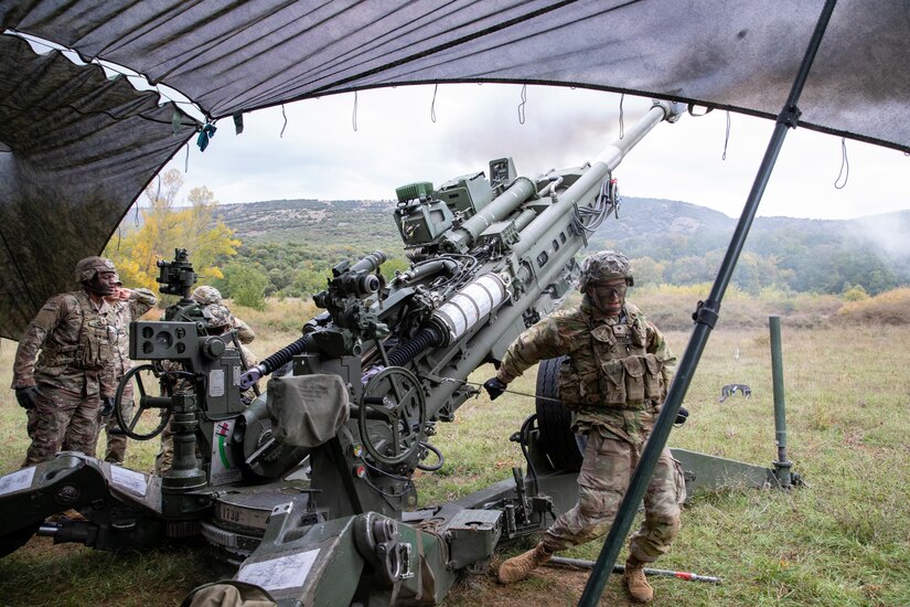 Soldiers fire a large weapon.