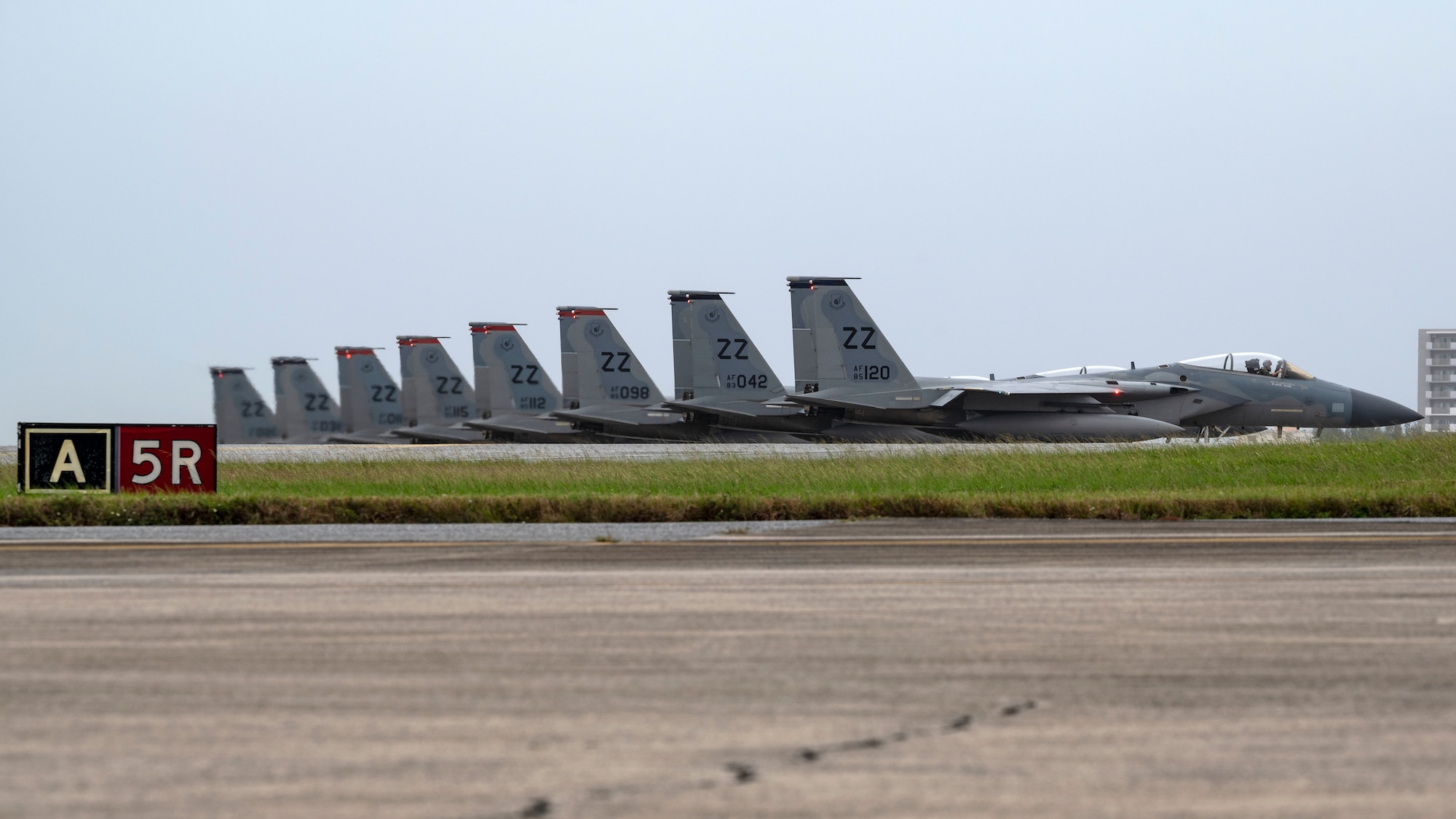 U.S. Air Force F-15C Eagles assigned to the 44th and 67th Fighter Squadrons await clearance for their last take-off from Kadena Air Base, Japan, Dec. 1, 2022. As a part of its modernization plan, the 18th Wing is retiring its aging fleet of F-15C/D Eagles that have been in service for more than four decades. (U.S. Air Force photo by Senior Airman Jessi Roth)