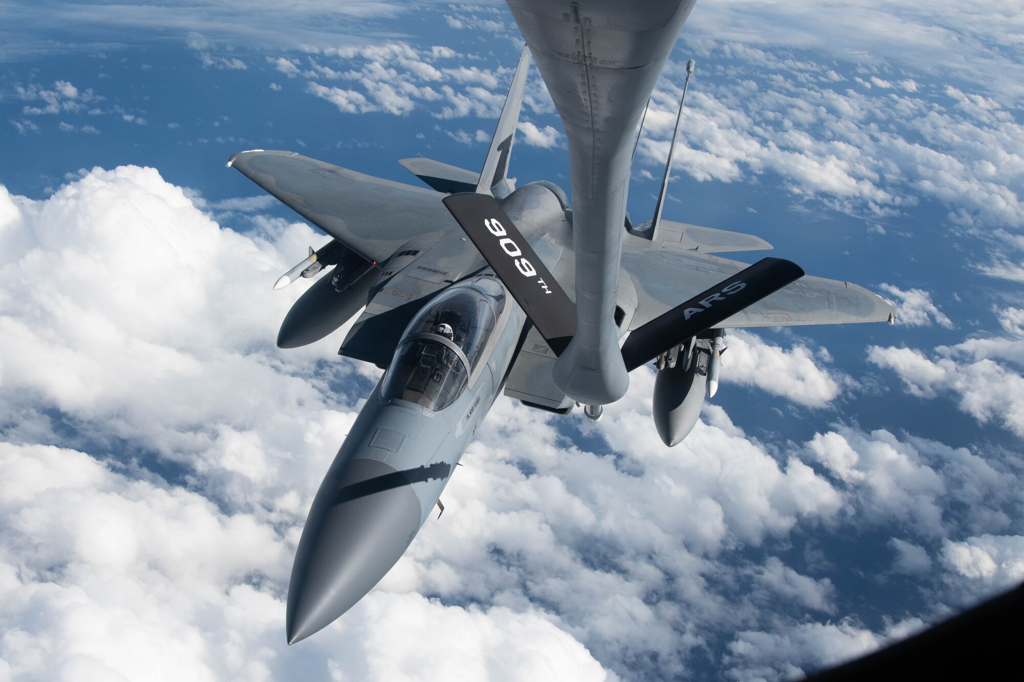 A jet gets refueled in the air.